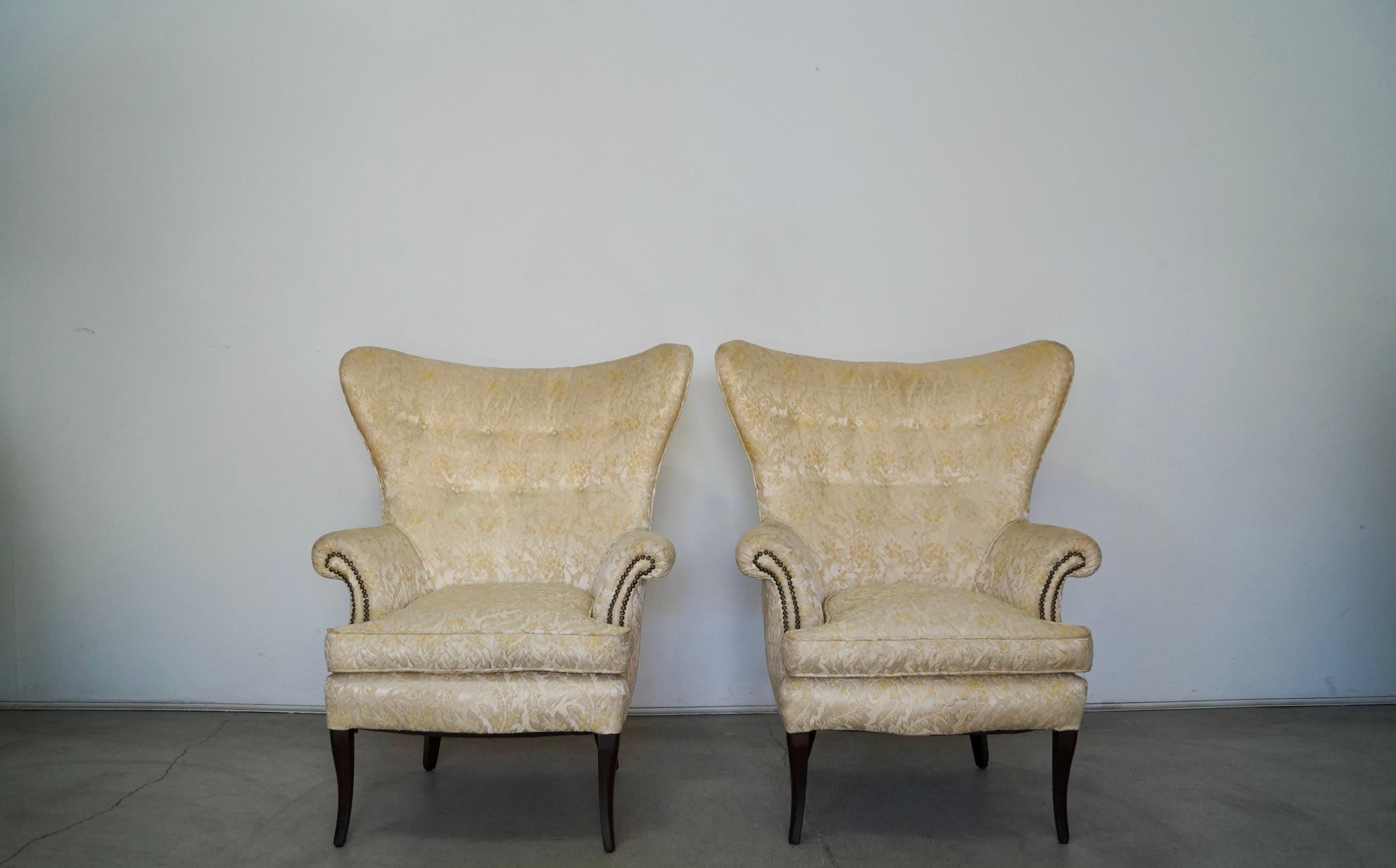Pair of 1950s Mid-Century Modern wingback chairs for sale. These are incredible, and have a butterfly wingback, and very well made. The frame seats have coil springs. The seat cushions also have coil springs. They have saber legs finished in a dark