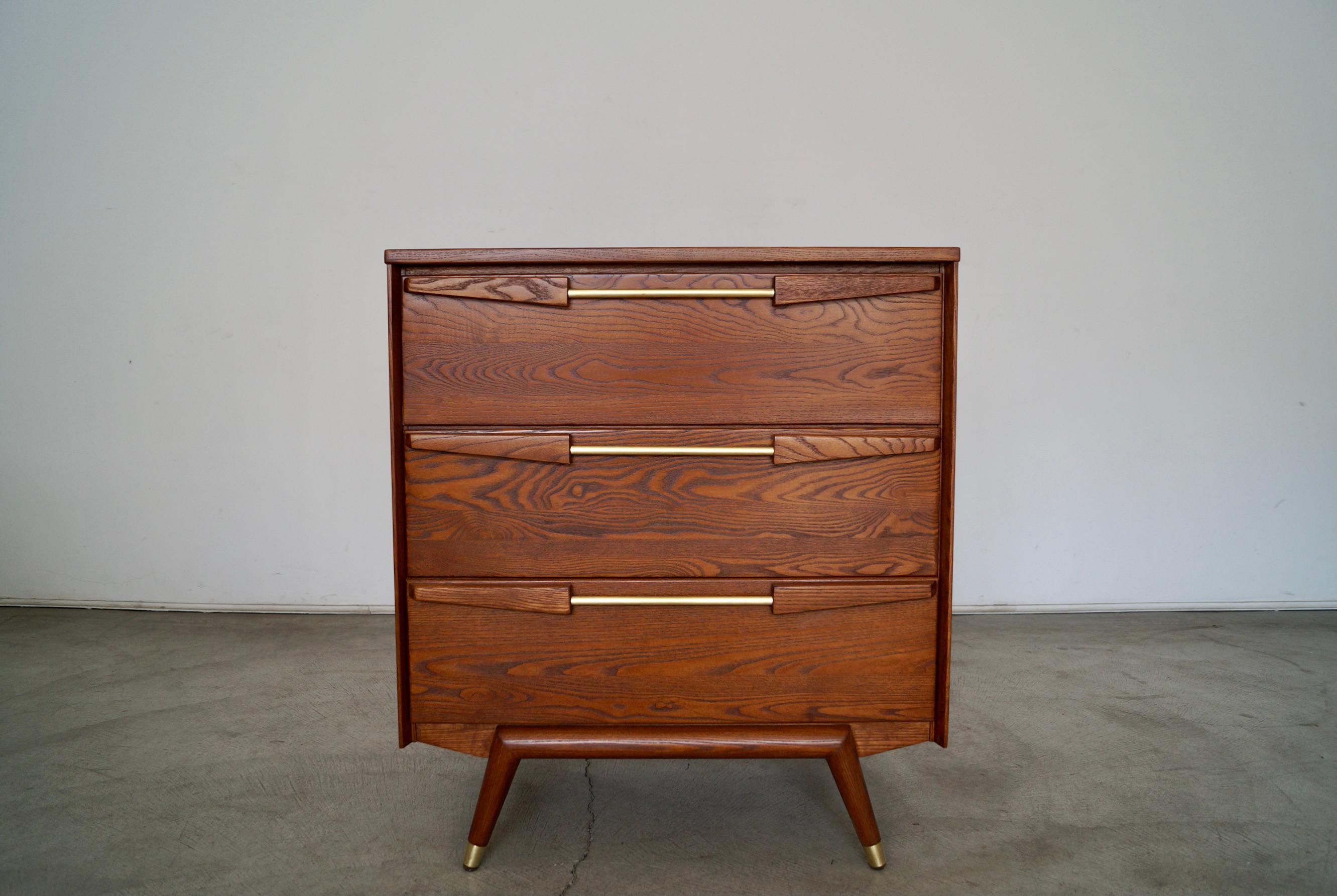 Mid-Century Modern dresser for sale. Made of solid ash and solid brass, and has been professionally refinished in walnut. It's really well made and solid, and has an incredible design. The interior of the drawers are metal. There is absolutely no