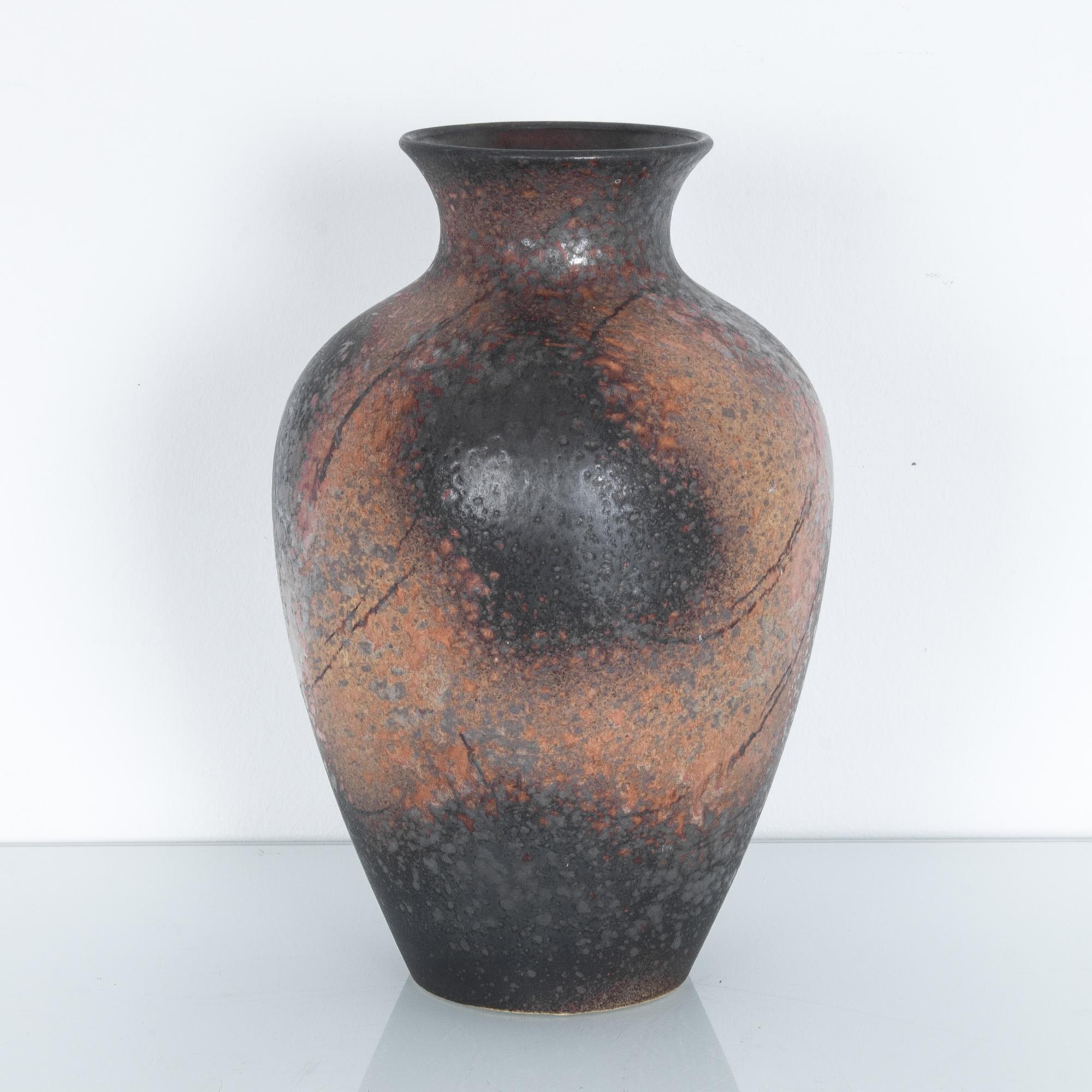 A ceramic vase produced in Germany, circa 1950. Glazed to highlight the natural texture of clay, a field of mottled orange and black. These characteristic mid-20th century ceramics were made in West Germany by a range of makers. High quality