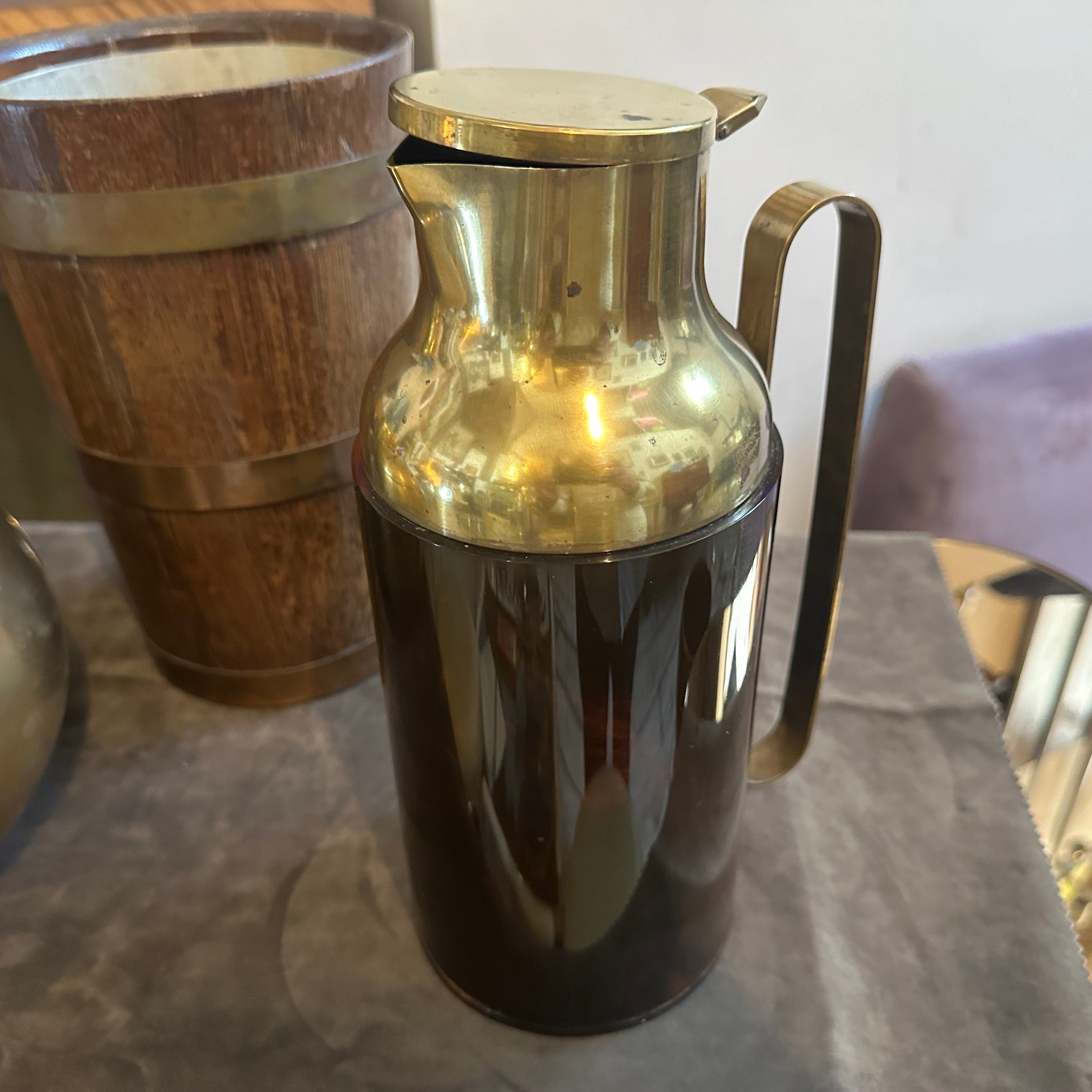 This 1950s Mid-Century Modern thermos carafe combines functional design with a touch of luxury through its use of Bakelite and brass. The body of the carafe is made from Bakelite, crafted to resemble tortoise shell, a popular motif in mid-century