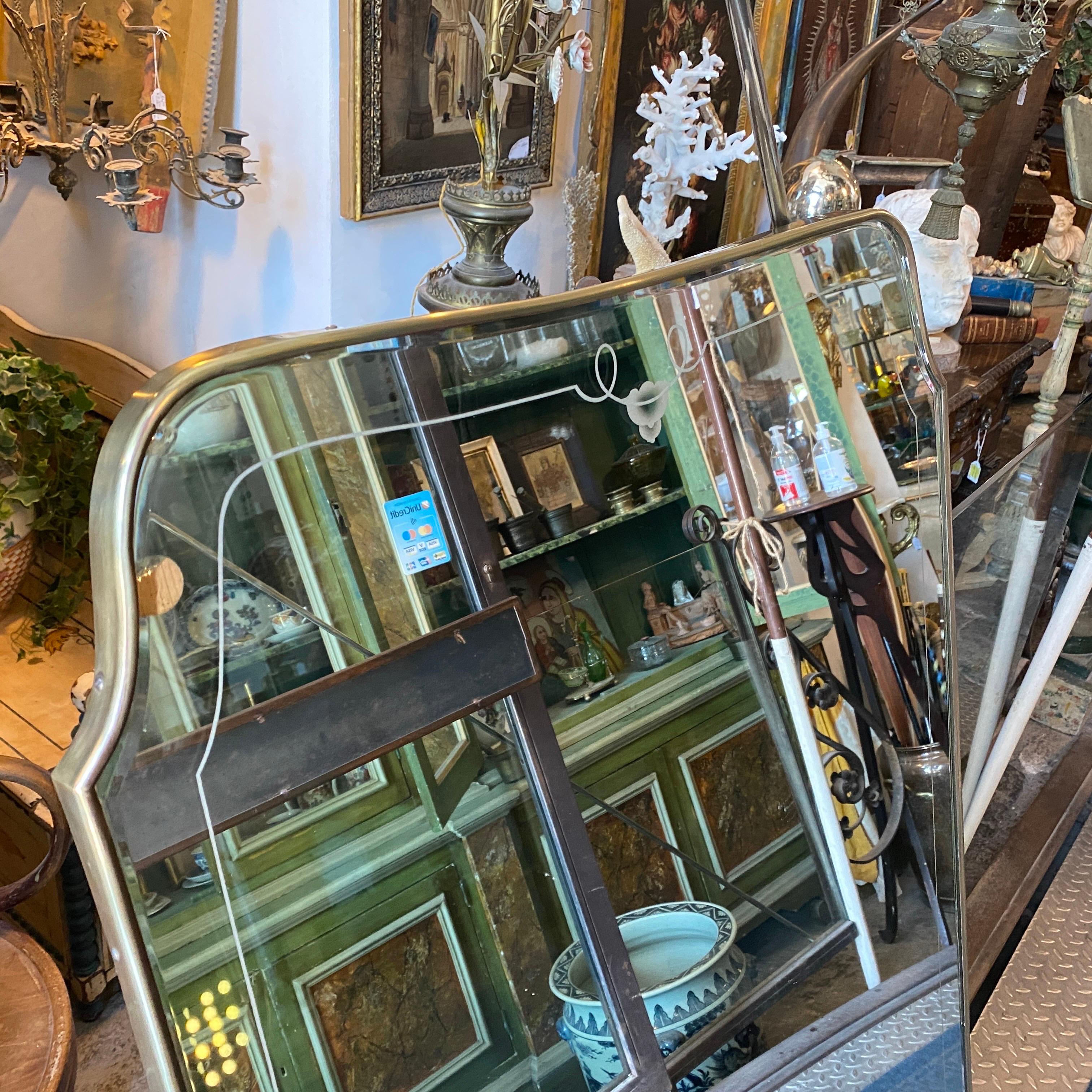 A solid brass and etched glass huge wall mirror designed and manufactured in Italy in the Fifties in the manner of Giò Ponti. The brass has a little crack bin the lower part visible in the last photo, the glasse has normal signs of use and age