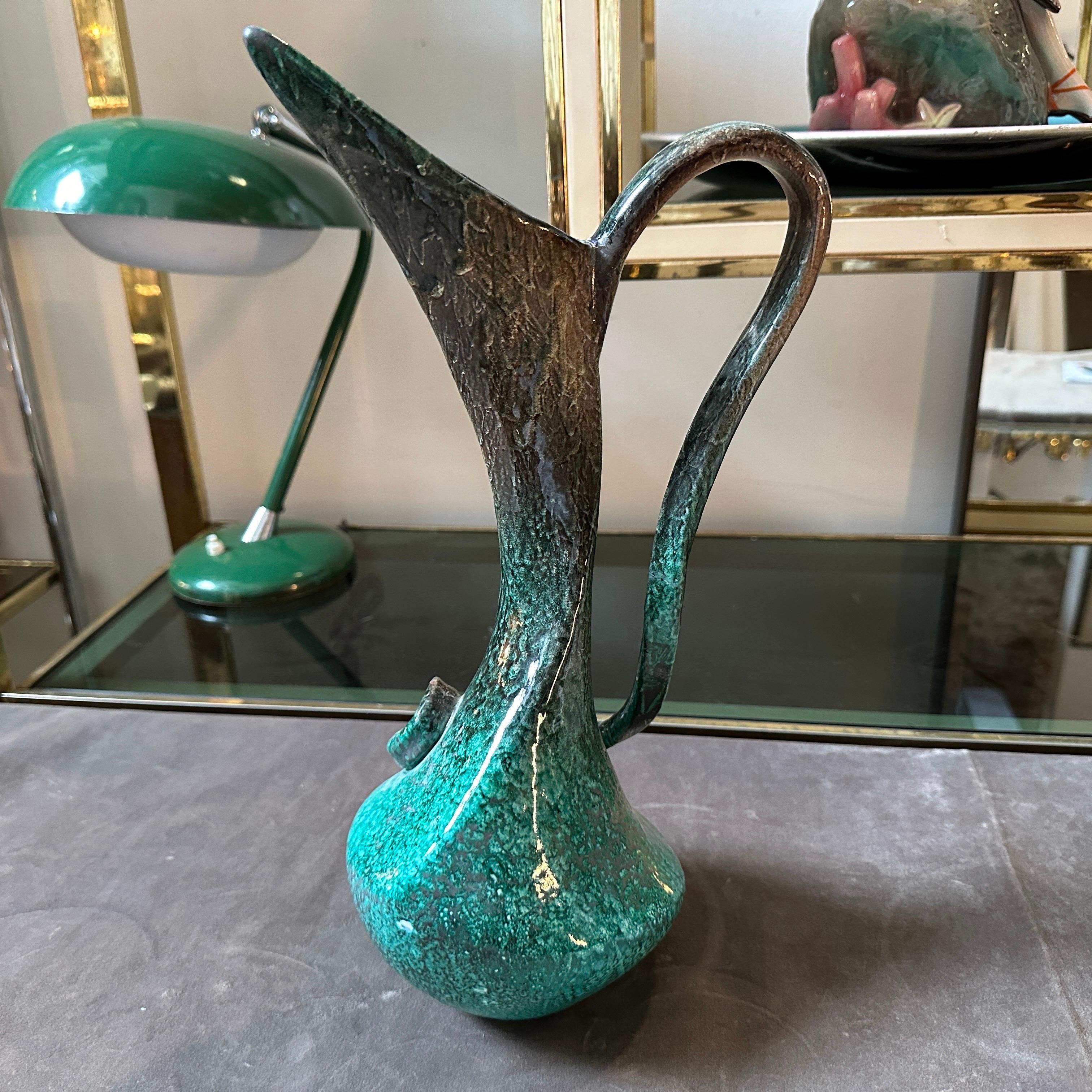 Vaso in ceramica verde della metà del secolo scorso, realizzato a mano in Italia negli anni Cinquanta, in buone condizioni generali con segni d'uso e d'età visibili nelle foto. Questo pezzo si distingue per la sua forma scultorea e per lo smalto