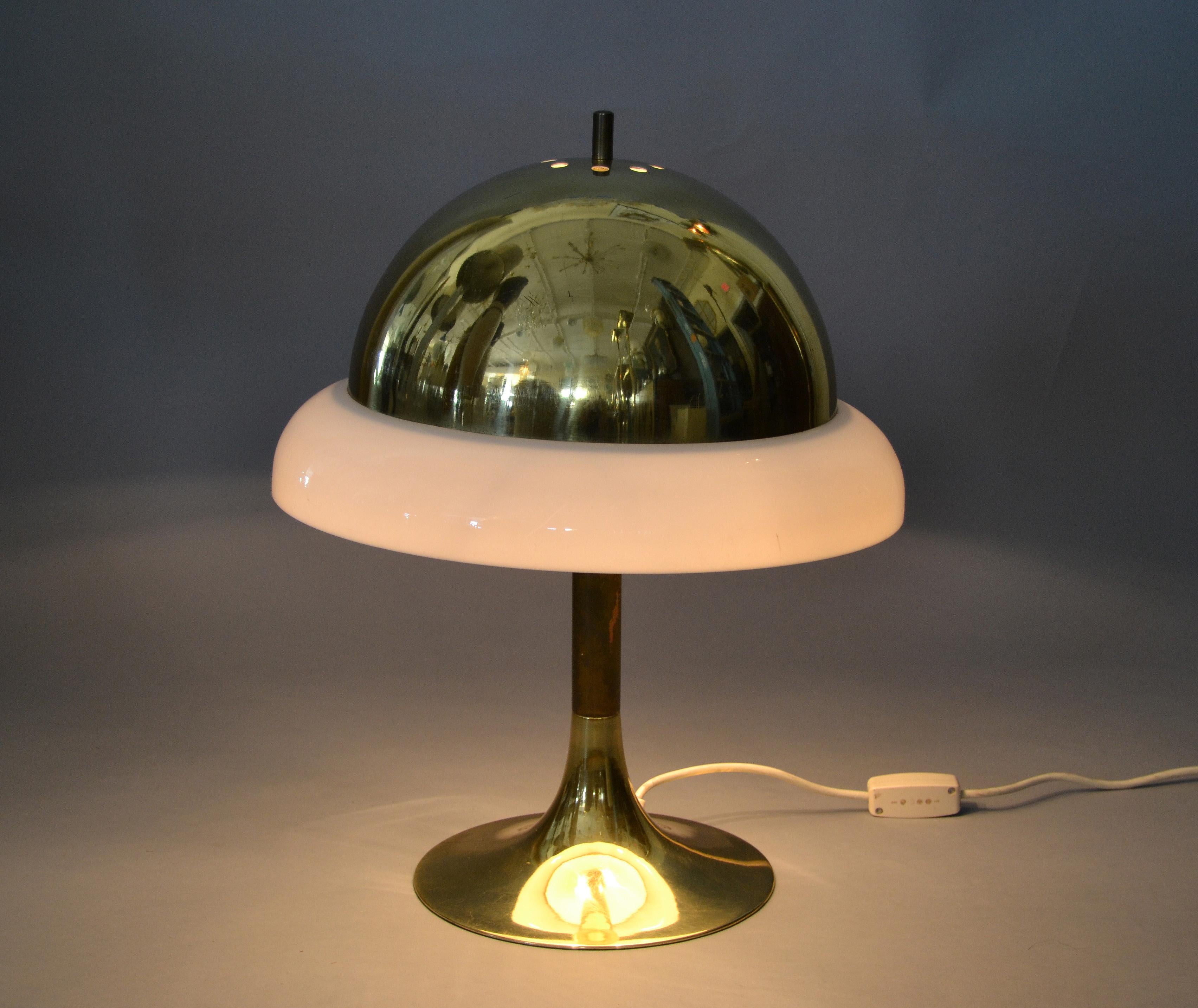 1950s Italian golden Mid-Century Modern desk lamp, table lamp in brass and plastic.
The shade is made out of brass and encircled with a plastic ring.
It is wired for the U.S. and uses 2 max. 40 watts candelabra light bulbs.
The table lamp is in