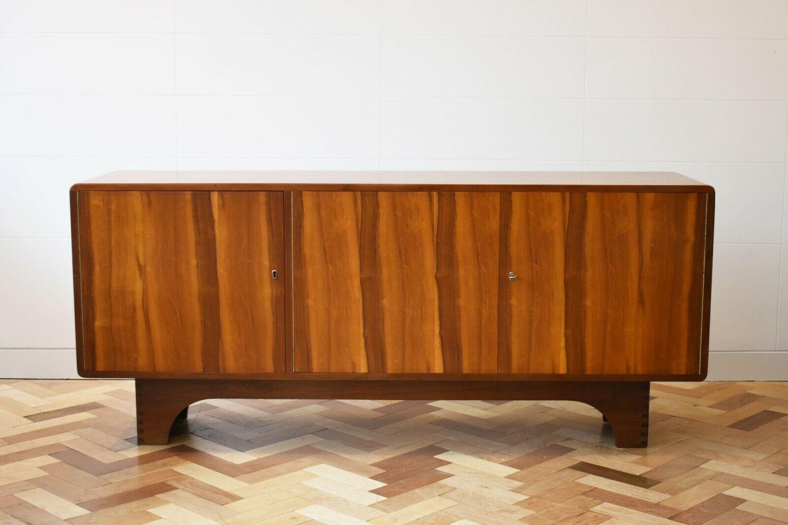 1950s Mid-Century Modern Italian walnut sideboard, in an Art Deco style

This rare 1950s walnut sideboard boasts a beautiful wood grain, whilst its curved corners add to its modernist elegance. 

With a range of storage spaces, 3 cupboards - one