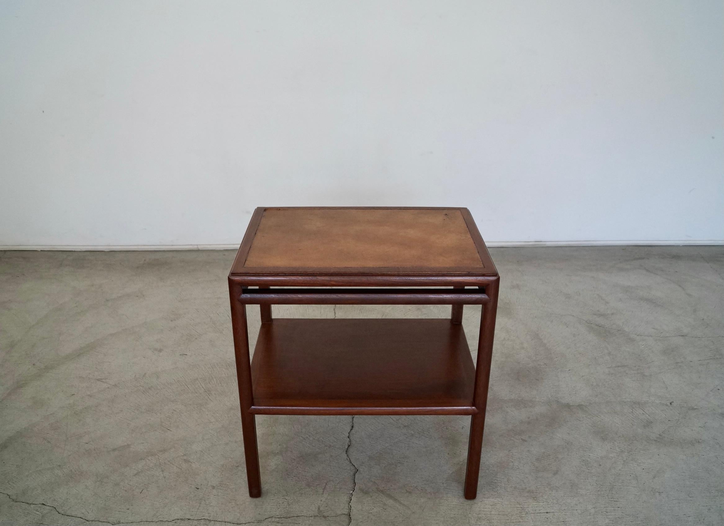 Vintage 1950's Mid-Century Modern side table for sale. In the manner of Edward Wormley for Dunbar, and has been professionally refinished in walnut. It has the original leather inlaid surface, and is rare. This table is a high-quality table