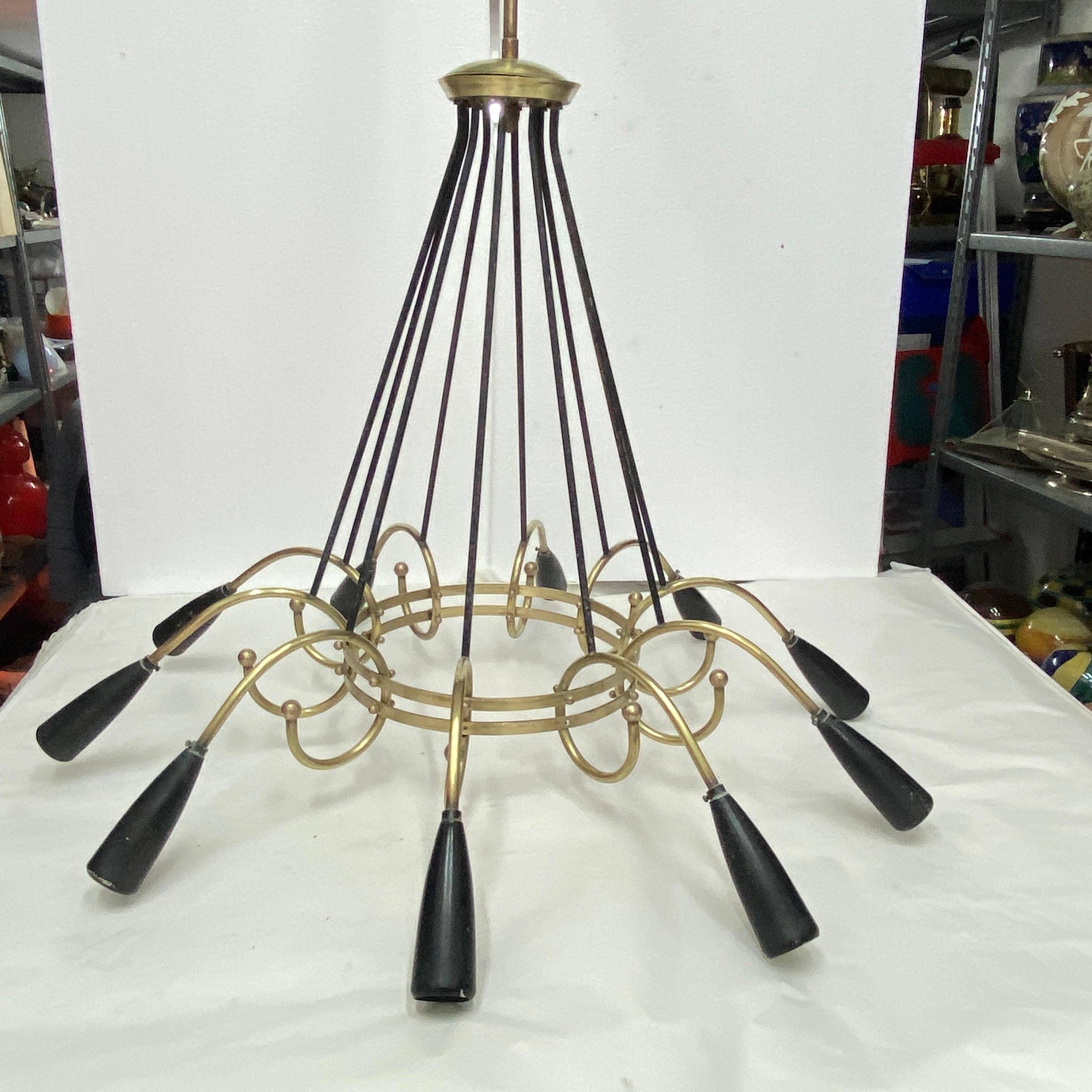 A brass chandelier designed and manufactured in Italy in the Fifties, it has been checked and it works 110-240 volts and needs 10 regular e14 bulb. Plastic black bulb holders are original. This Sputnik Italian Chandelier is a timeless piece of