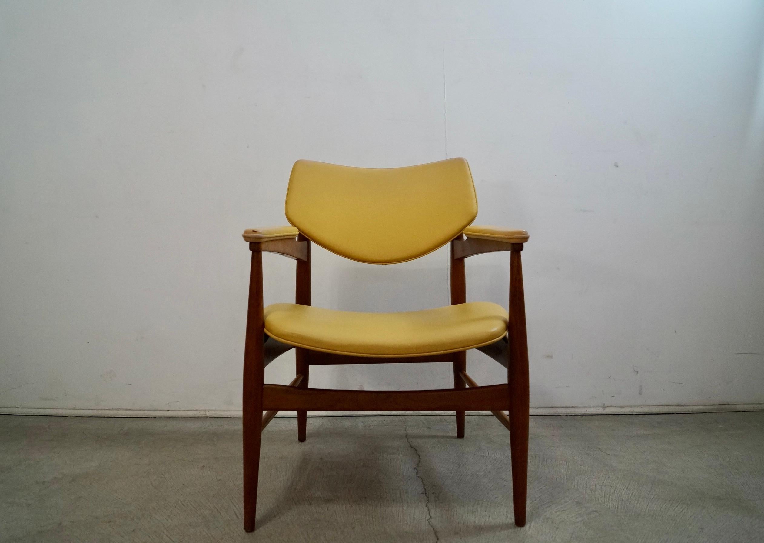 Vintage original Midcentury Modern armchair for sale. Manufactured in the 1950's by Thonet, and still has the original tag nicely intact. It has the original naugahyde vinyl upholstery in yellow and shows some vintage wear. The solid walnut frame