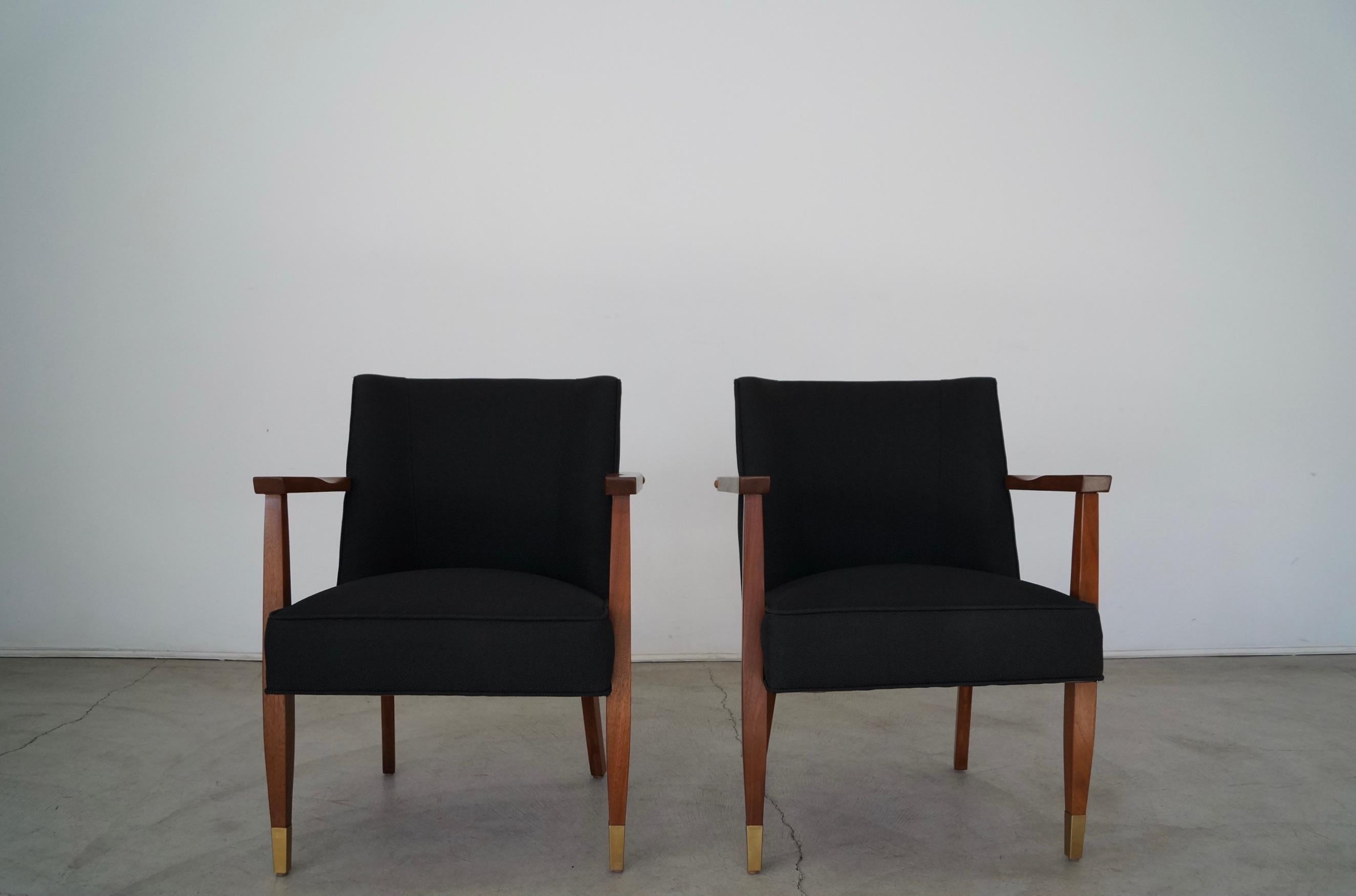 Vintage Mid-Century Modern pair of arm chairs for sale. From the 1950's, and have been professionally restored. They solid walnut frames have been refinished in natural walnut, and have solid brass caps on the tips of the front legs that have been
