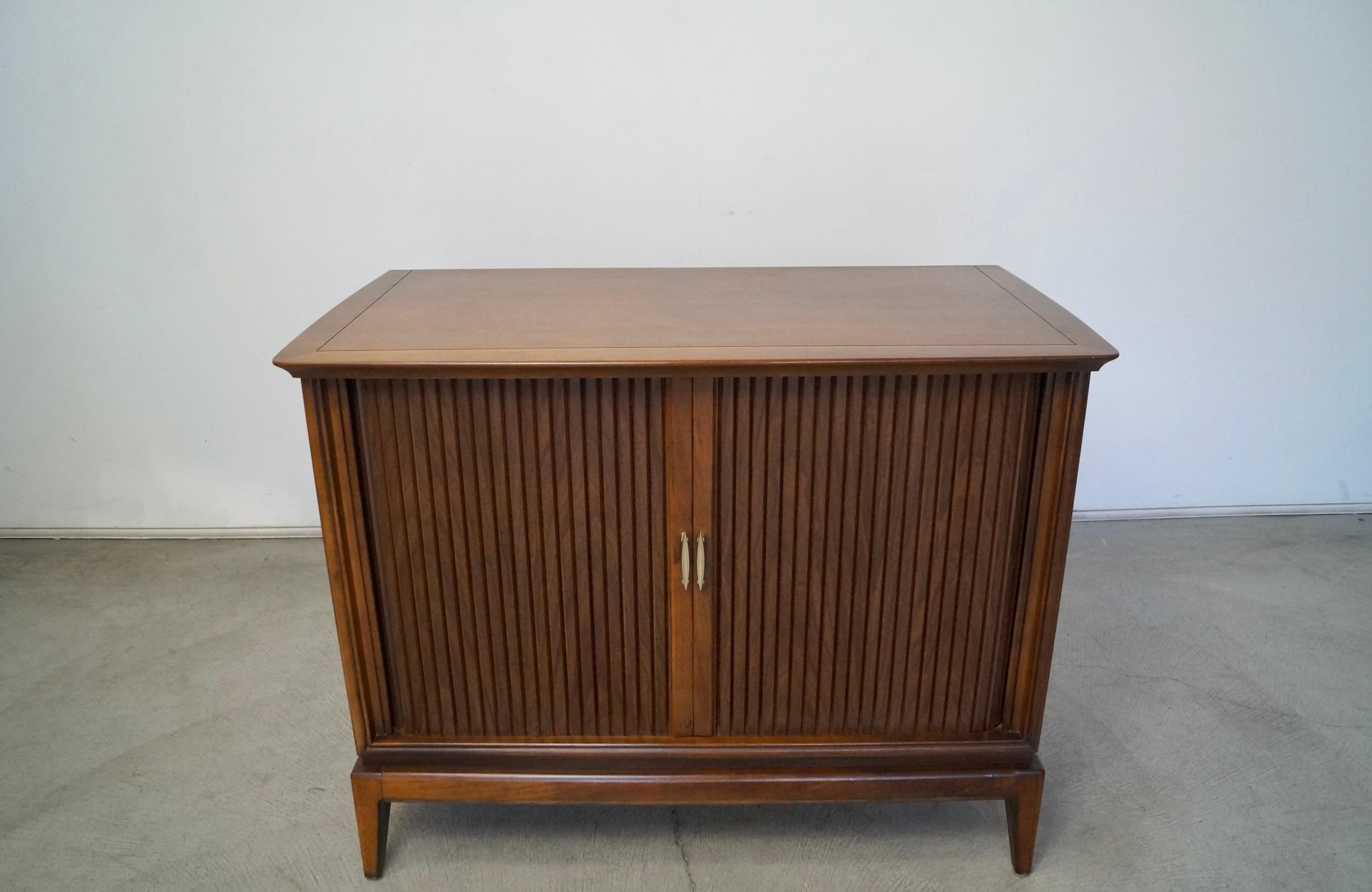 Vintage Mid-Century Modern TV console for sale. Manufactured by Magnavox in 1957, and is in incredible original condition. It's a tambour door credenza / cabinet that opens up to a TV. It turns on and there is still sound. Not sure if it can give