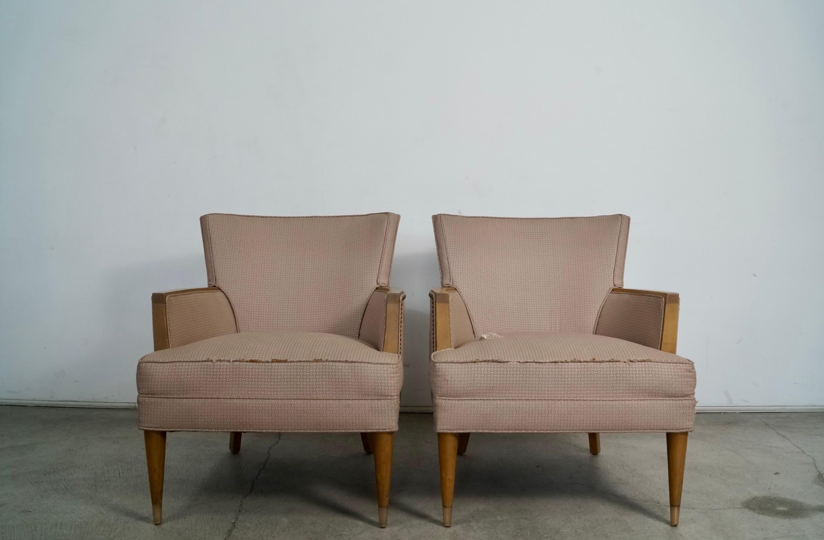 Pair of vintage Midcentury Modern armchairs for sale. Original vintage from the 1950's. They have the original pink vinyl and brass nailhead trims on the back. The arms are solid wood with tapered wood legs and solid brass caps on the legs. They