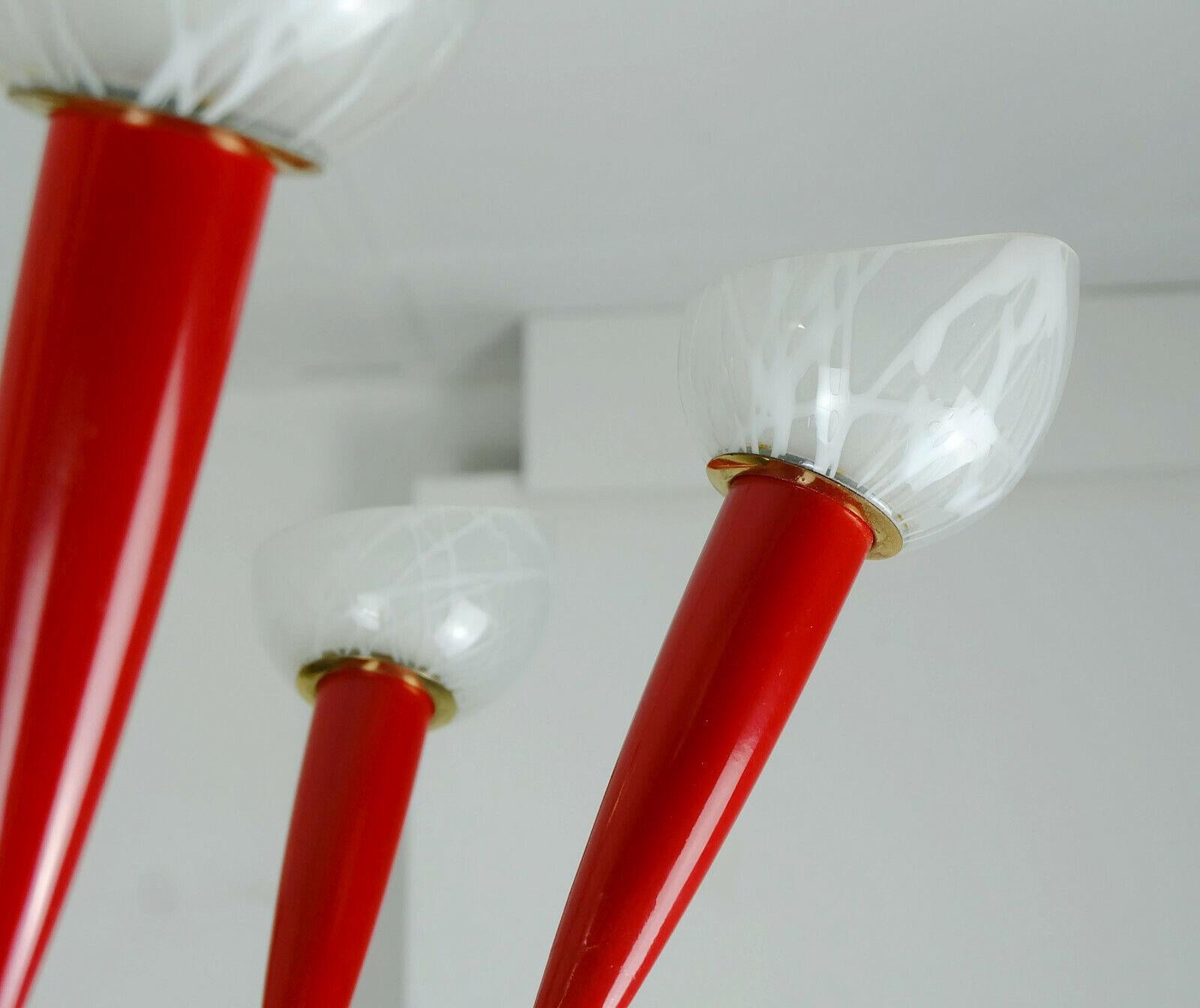Fantastique et élégante lampe à suspension des années 1950. Réalisé en laiton, métal laqué rouge (au centre), plastique rouge et verre blanc. Contient 7 ampoules E14 (les ampoules sur les photos ne sont pas incluses dans le prix).

Très bon état,