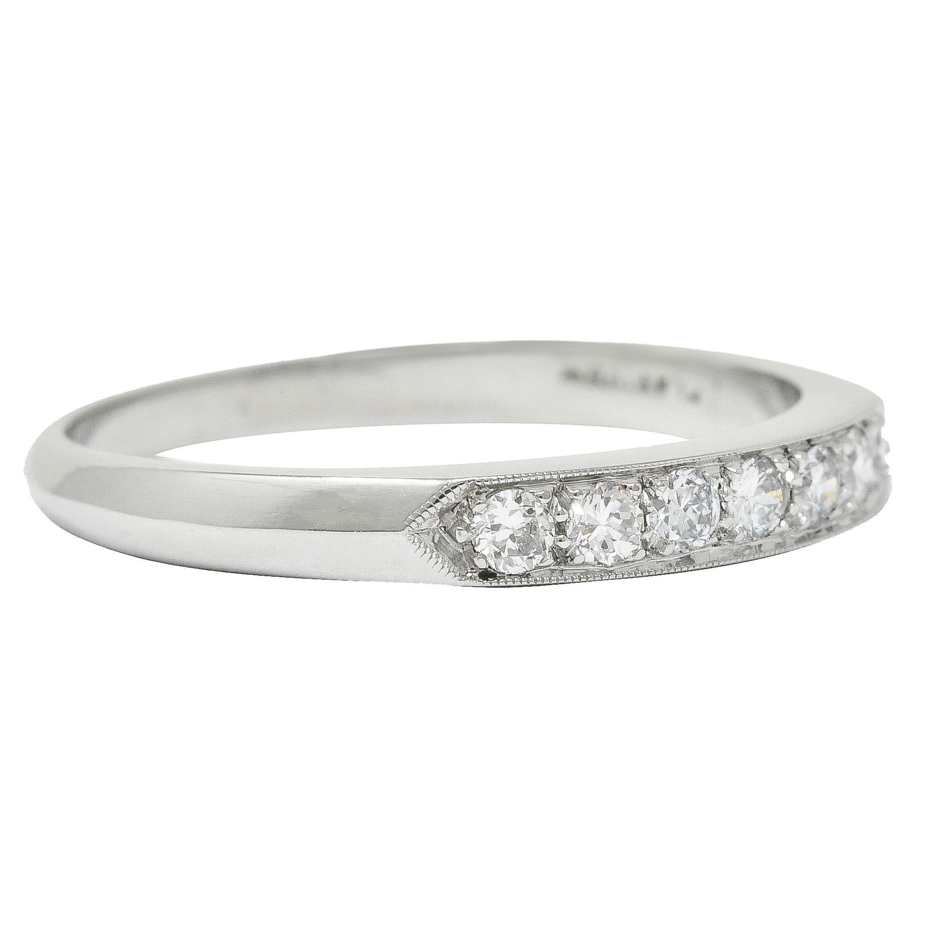 Band ring is set to front by seven round brilliant cut diamonds

Weighing in total approximately 0.25 carat with H to K color and VS clarity

Bead set in a recessed channel with pointed shoulders and a milgrain edge

Completed by a subtle knife