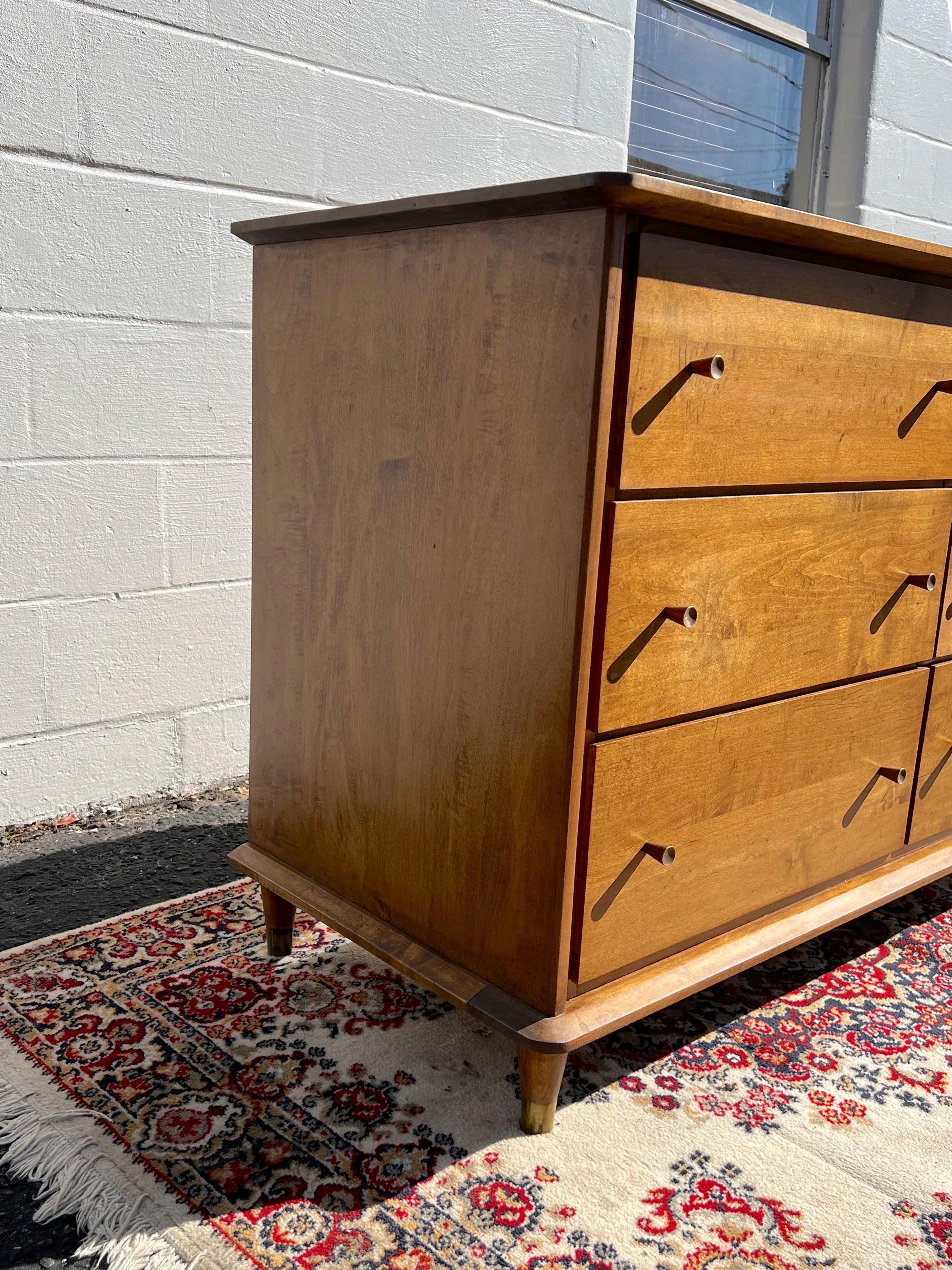A newly refinished solid wood (no veneer) 6 drawer dresser with original McCobb style brass drawer pulls. This piece is very heavy and very well made. All drawers have been checked and repaired so they glide like butter. A fantastic vintage piece to