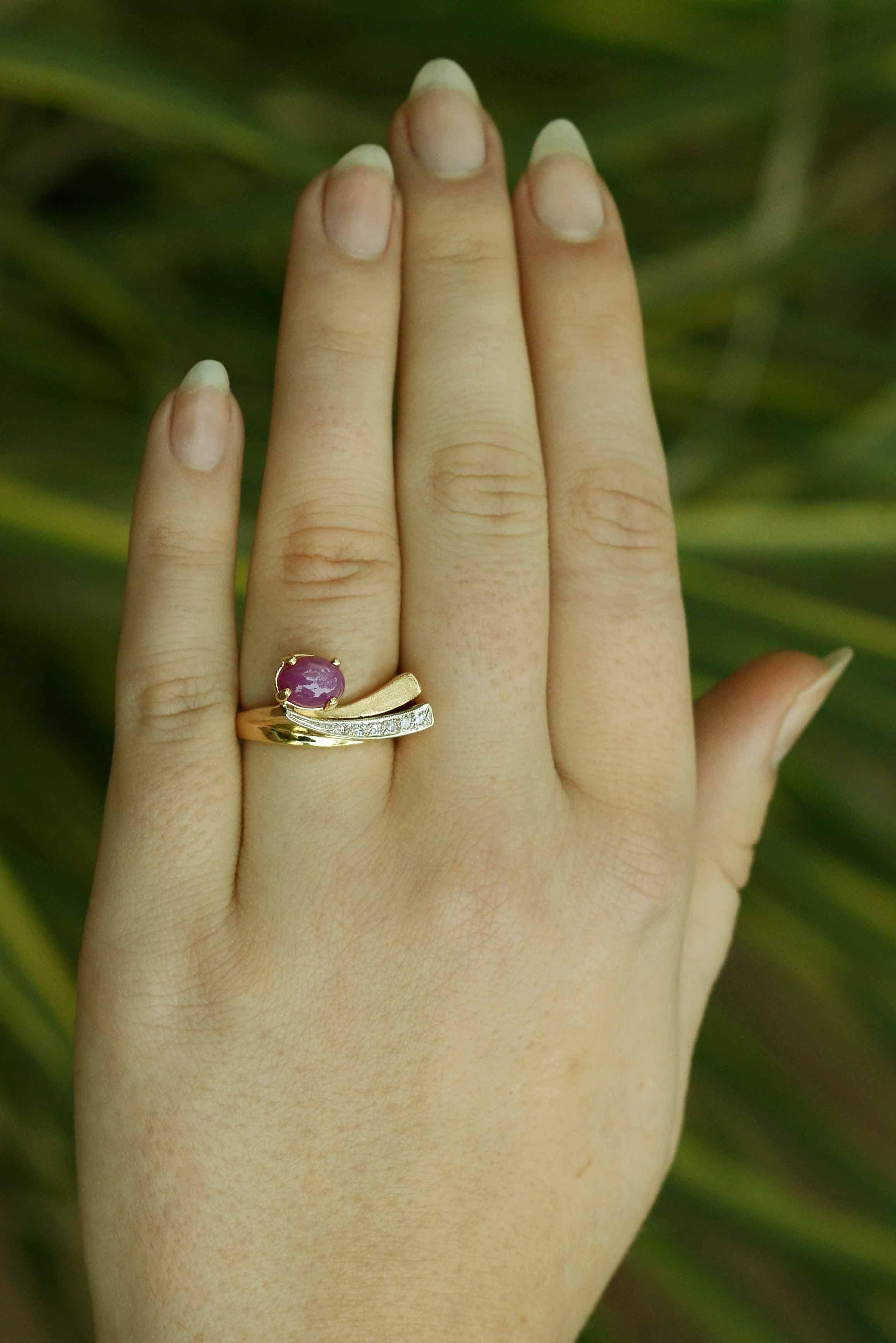 A mid century ring that shows impressionist and creative architecture, depicting a shooting sapphire star. This prominent star's rays emanate from a luscious pink star sapphire and is contemporarily placed alongside the arcing bands, crafted of 14K