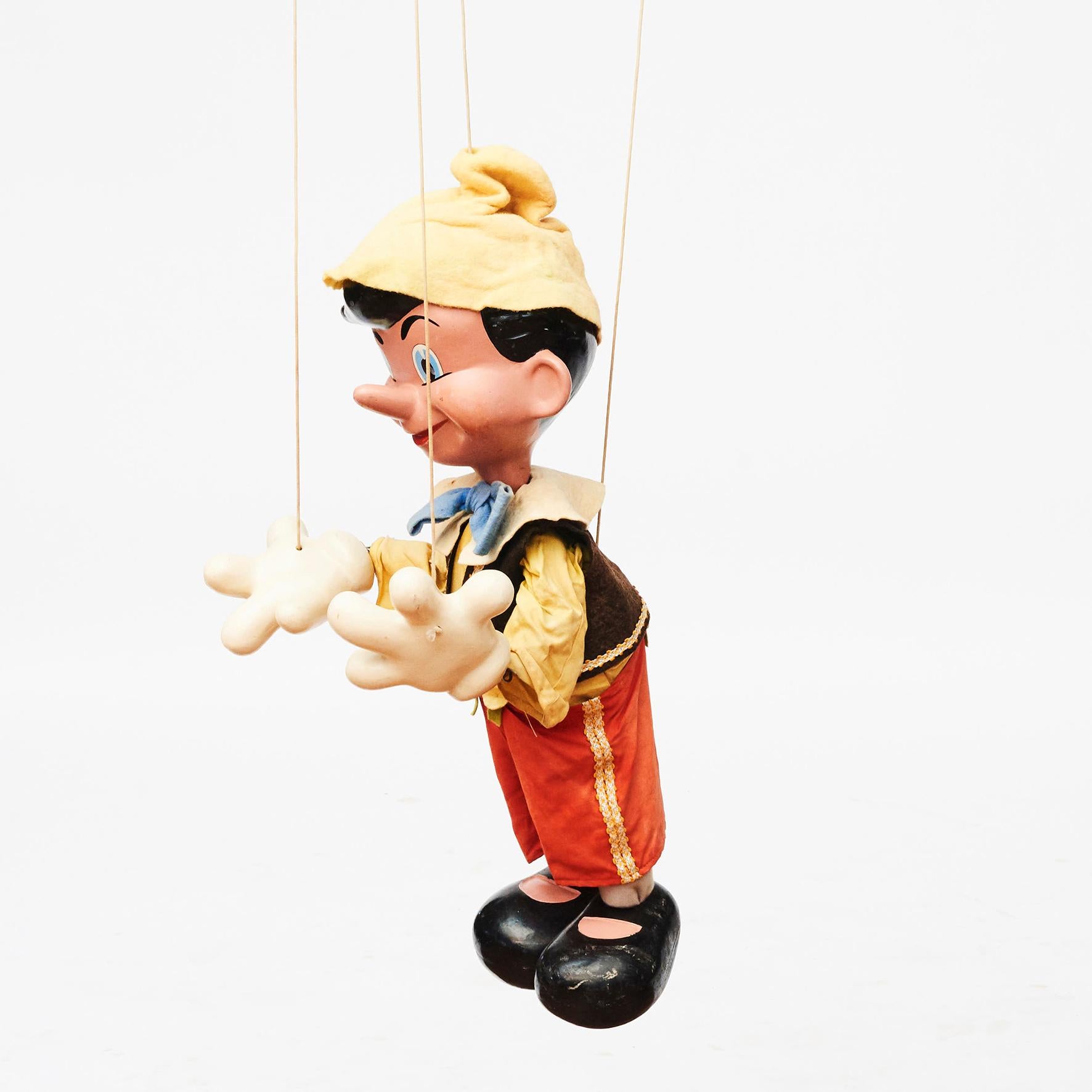 Excellent handmade vintage Pinocchio marionette puppet. 
Modelled after the Walt Disney character by Pelham Puppets, England 1960s.

Features moulded head, hands and feet hand painted with blue eyes and black hair, wood and cloth body. He is