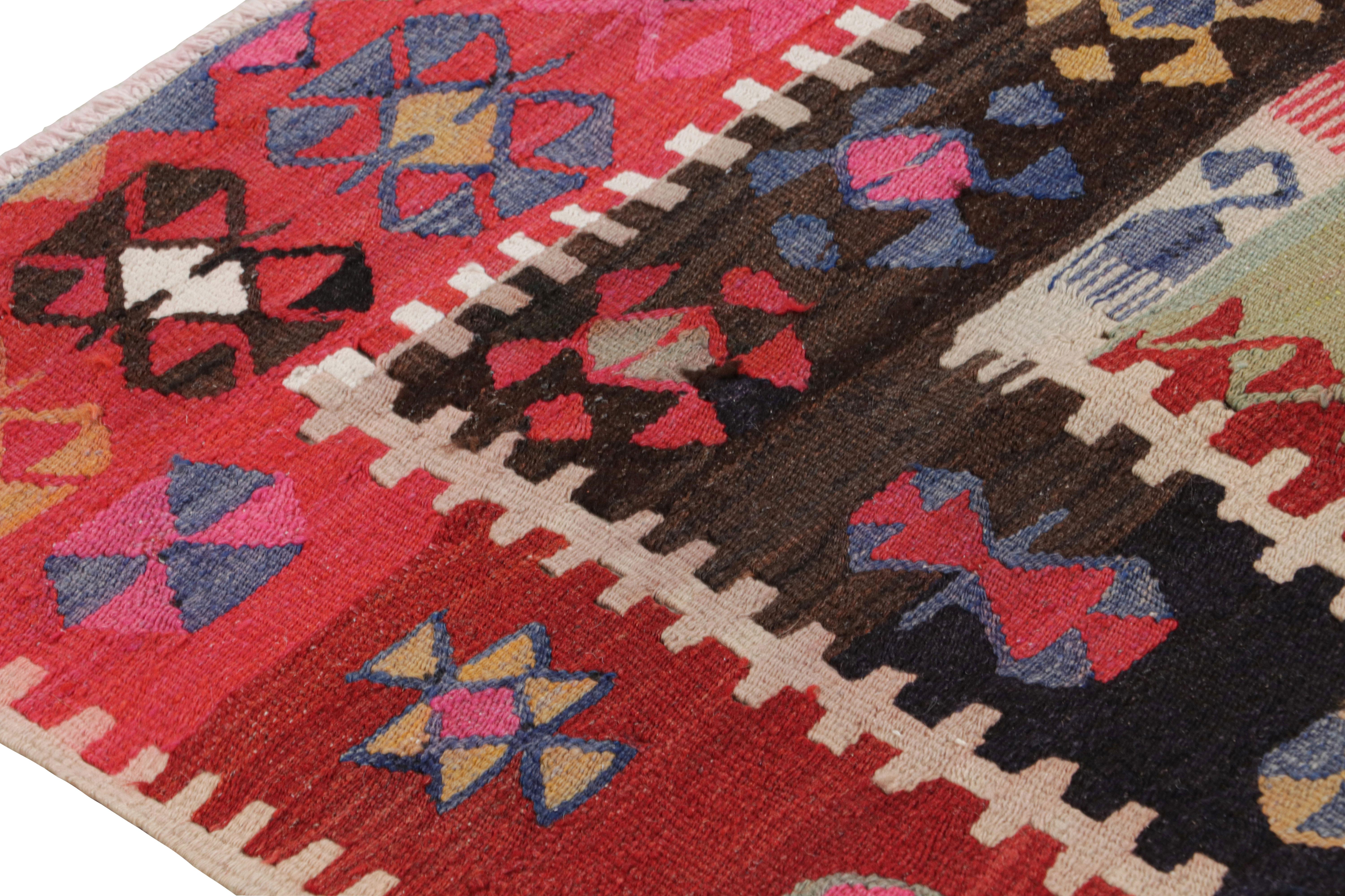 Dieser handgeknüpfte Wollteppich aus der Türkei (ca. 1950-1960) ist ein klassisches anatolisches Teppichdesign mit farbenfrohen Stammesmotiven in spielerischen Variationen vor dem Hintergrund der vorherrschenden, satten Rot- und Grüntöne. Unter den