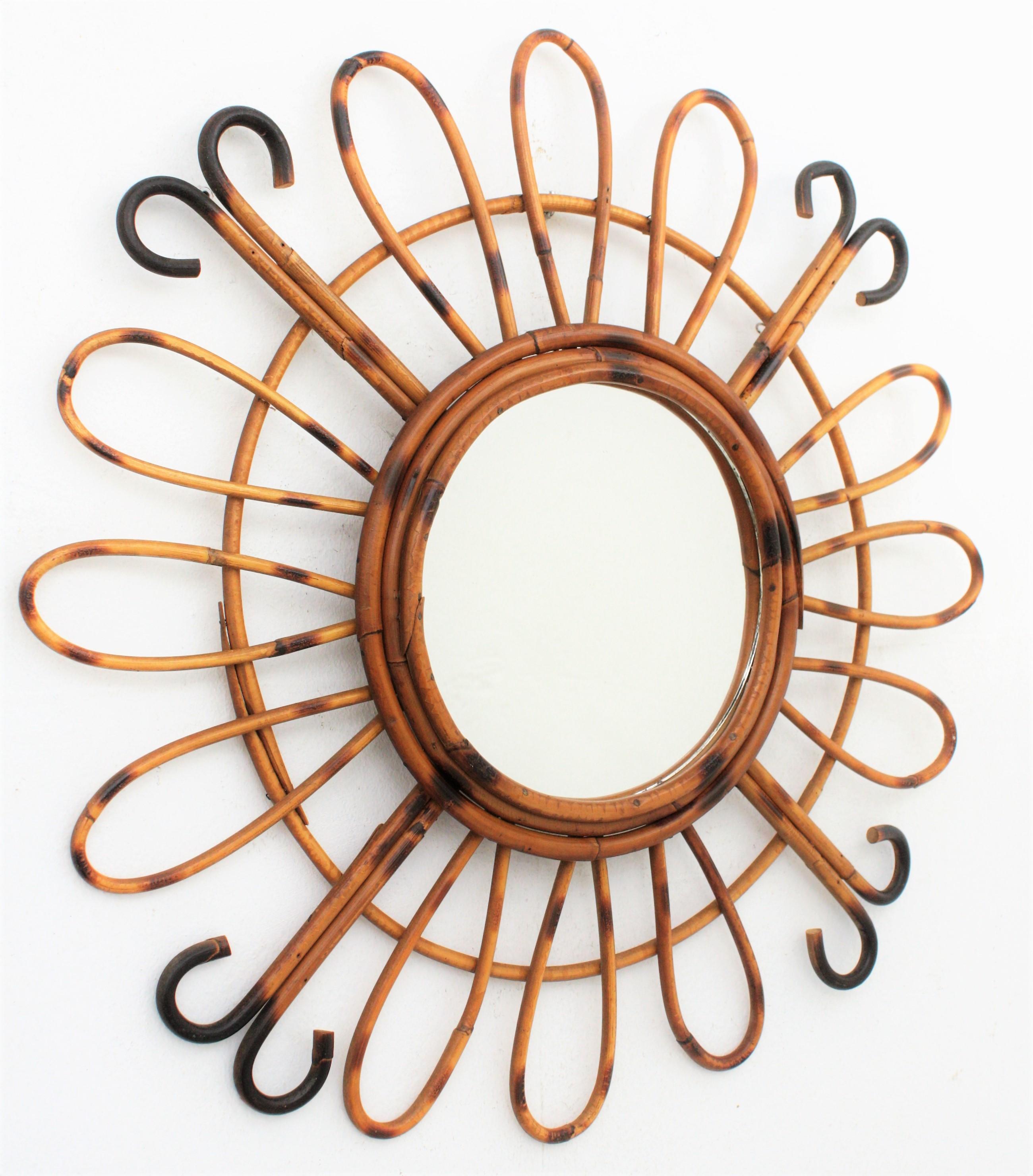 Beautiful handcrafted rattan and bamboo mirror with pyrography decoration .A circular glass framed by three bamboo cane laps and adorned by an alternating composition of three petals and two curved rays. This piece has all the taste of the French