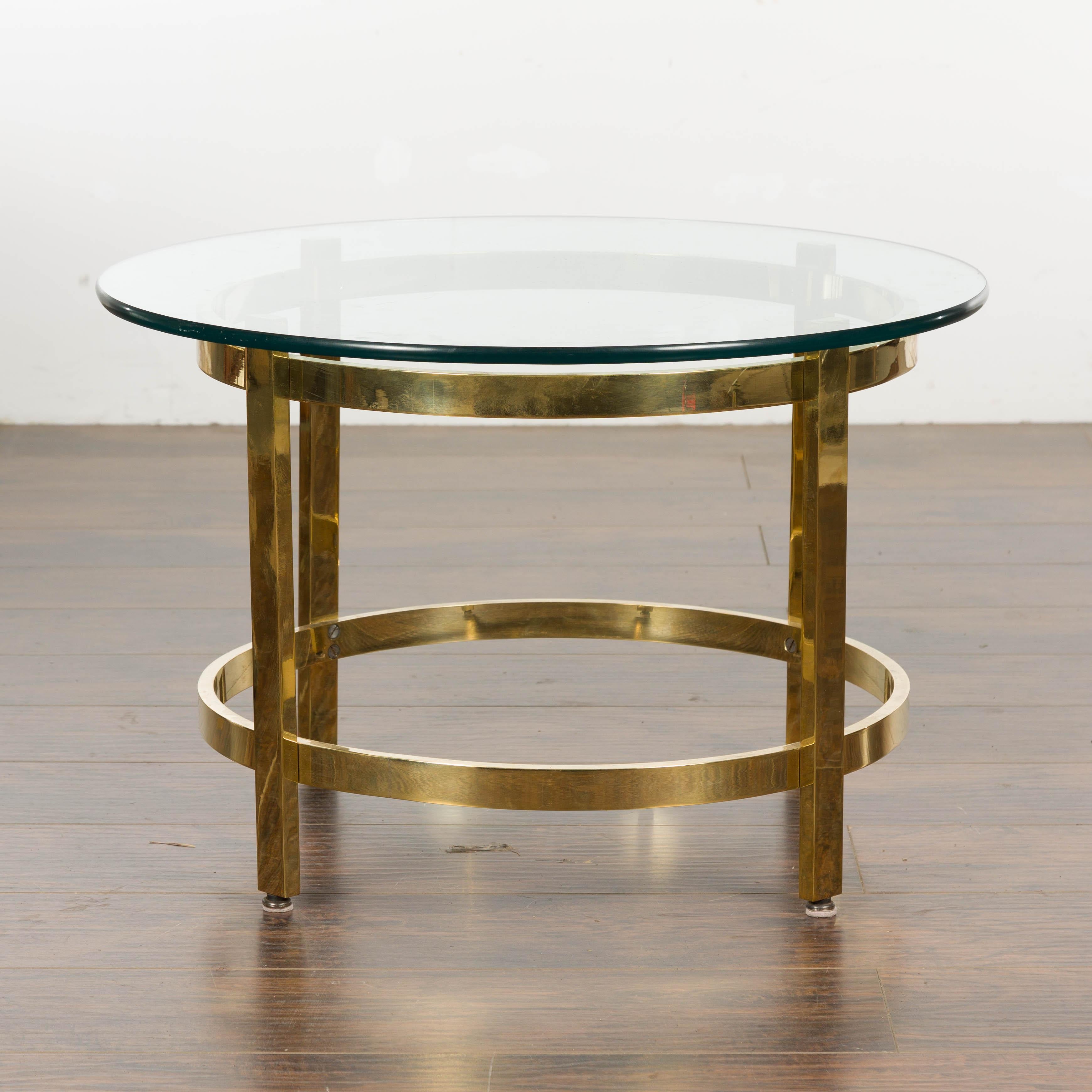 An Italian Midcentury brass side table from circa 1950 with circular glass top. Indulge in the elegance of the 1950s with this Italian Midcentury brass side table, a manifestation of timeless design and suave style. Merging the functionality of a