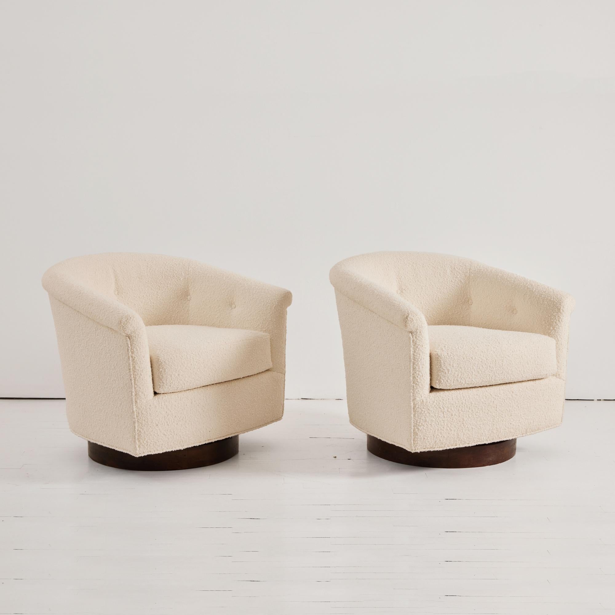 These classic swivel chairs are attributed to designer Milo Baughman. Fully reupholstered in an Ivory Boucle, tufted buttons at the back seat and wood swivel base. These chairs are timeless in their appeal