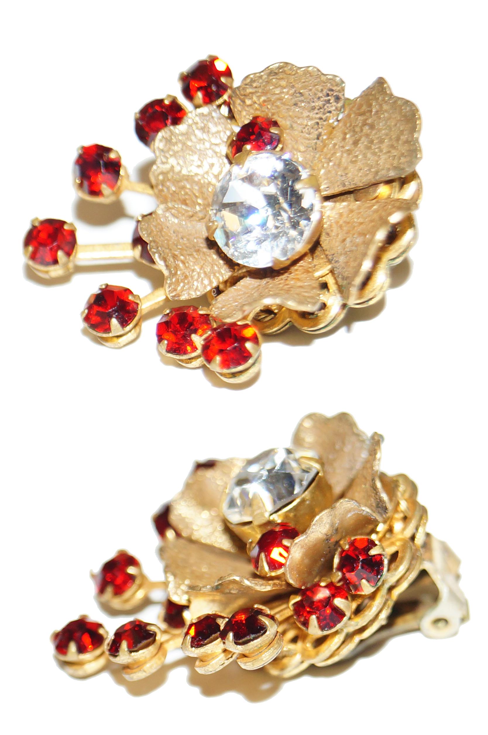 Simple and elegant floral rhinestone earrings by Miriam Haskell. The earrings are composed of a brilliant large silver rhinestone center with smaller red rhinestone accent, a gold tone floral body with lightly textured petals, and a spray of red