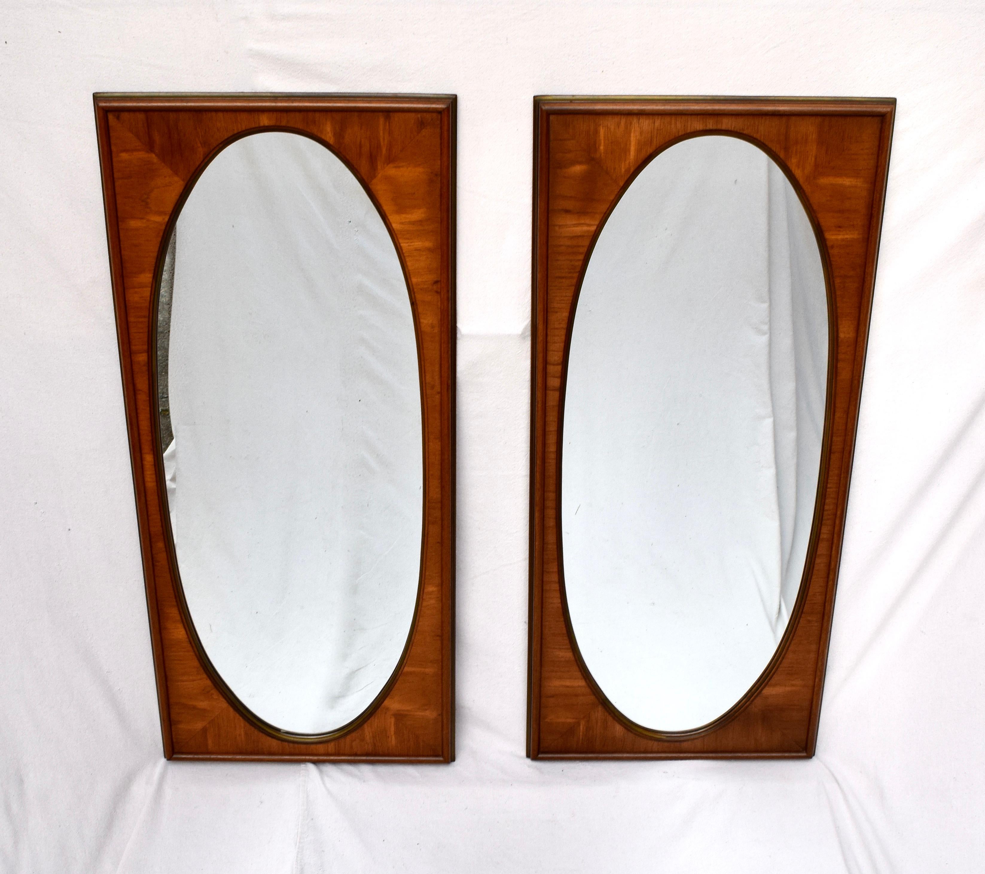 A set of early 1950s mirrors by White Furniture Company of Mebane, NC. Impressive book matched walnut veneers & interesting oval forms within the rectangle frames offer versatile design elements suitable for placement options from Classical to
