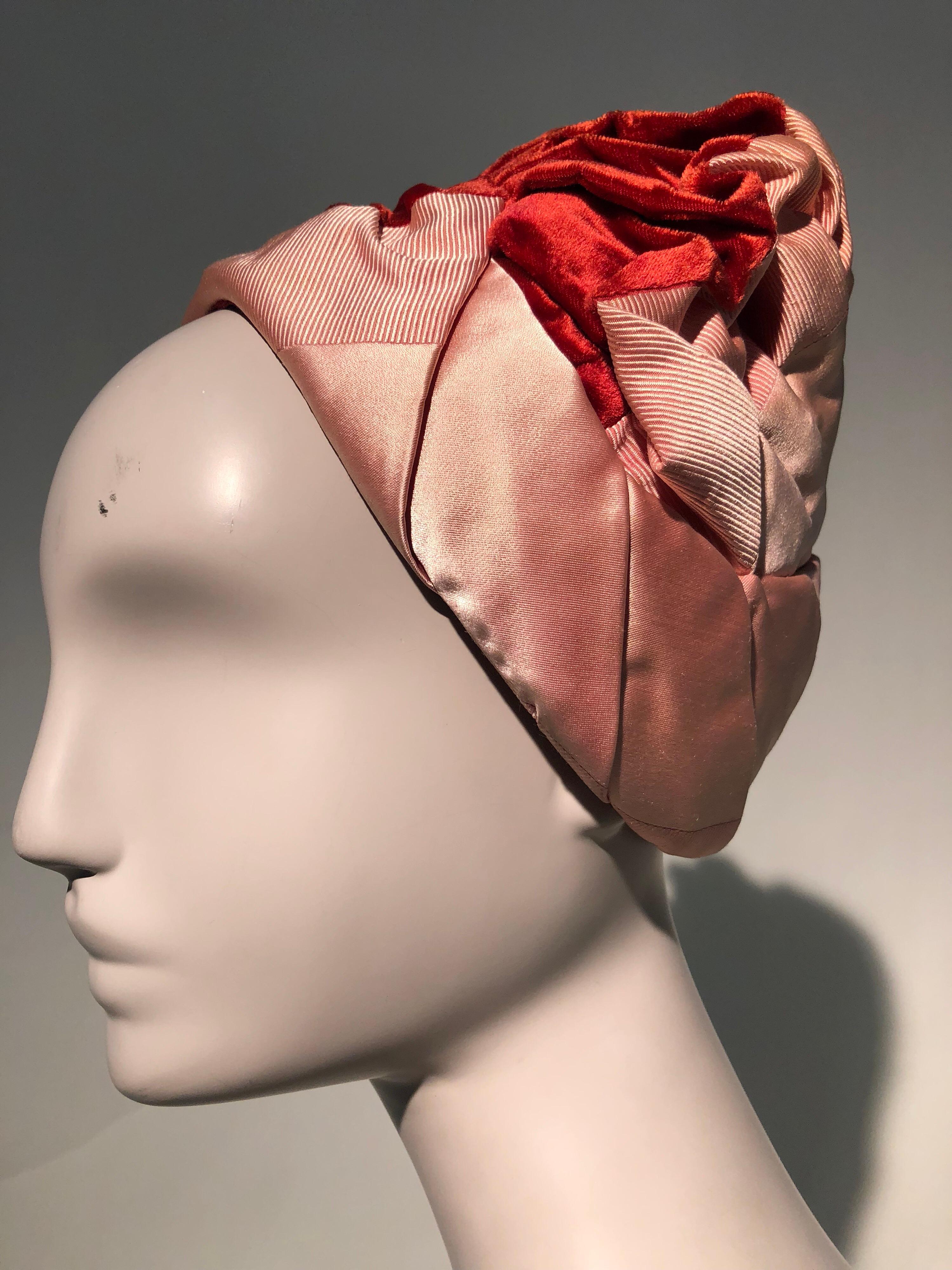 Un magnifique chapeau style turban des années 1950 de Christian Dior en velours rouge, satin rose et faille. Une rangée de fronces souples au niveau de la couronne confère à ce chapeau un beau volume. La base est une dentelle raidie. 