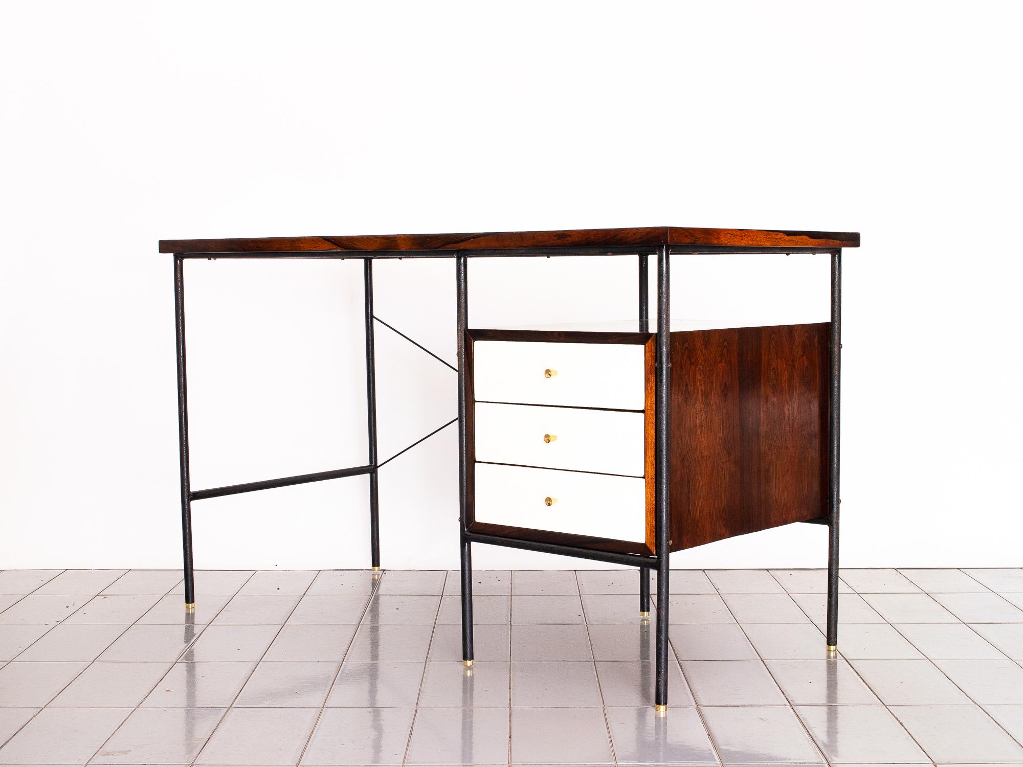 The small '1015' desk is an iconic piece of Brazilian design, with striking contrast between the white Formica and the Iron - Rosewood. Brass feet and pulls complete the details of a perfect Minimalist piece. 

The desk was designed in the 1950's by