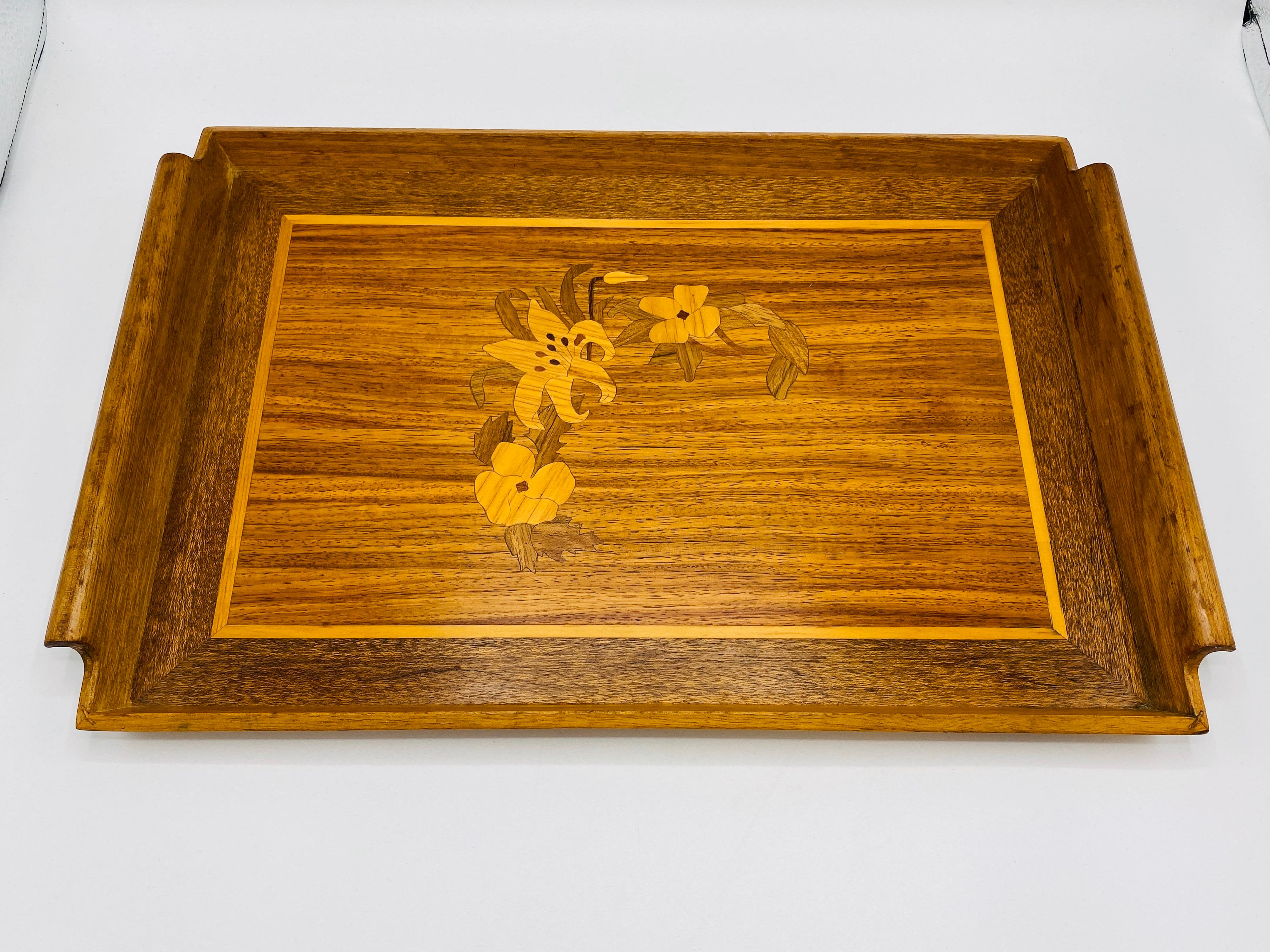 Listed is a fabulous, 1950s modern-chinoiserie walnut tray. The piece has a floral motif inlay, with hand-carved rolled handles on two sides. Weighs 1.7lbs.