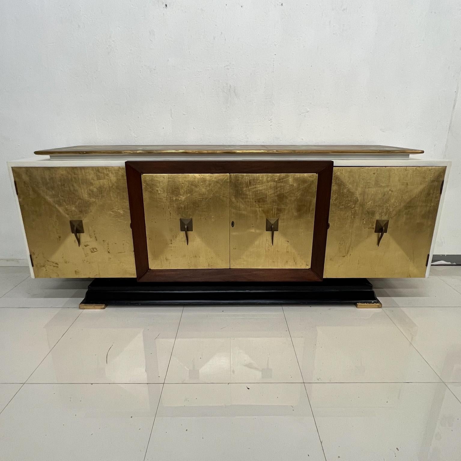 1950s Modern Neoclassical gold leaf credenza cabinet mahogany wood and brass Mexico.
Measures: 95 W x 36.5 tall x 22 D Drawer 20 x 13 D x 3 tall.
Storage right and left 18 x 12 at bottom and 8.5 top 26 wide Middle storage 41.5 W x 17.5 top, bottom
