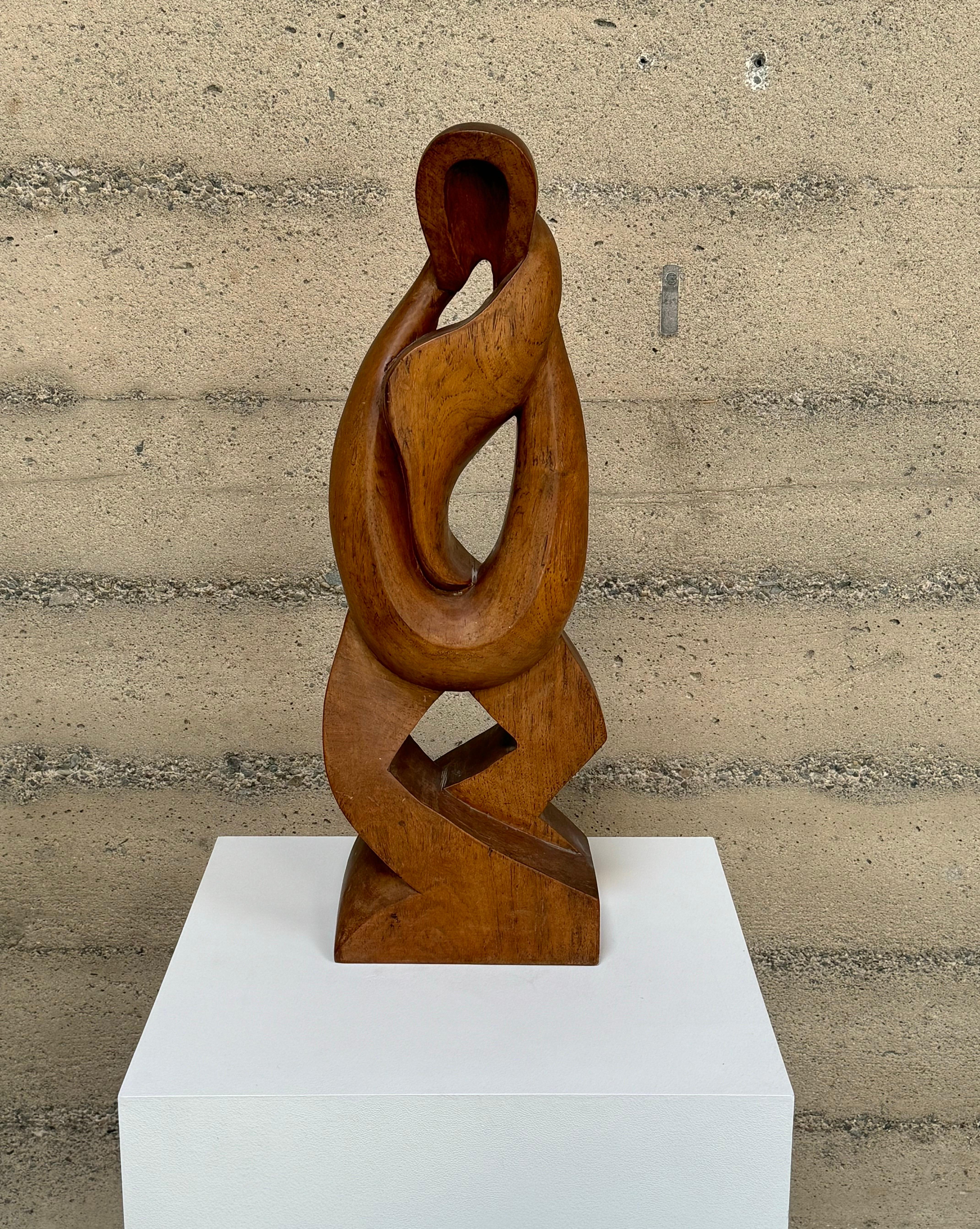 A 1950s modernist hand carved figurative abstract sculpture in walnut. A symmetrical form with flowing movement in its shape, starting from the top and with its culmination at its wide base, with nice graining to the walnut.