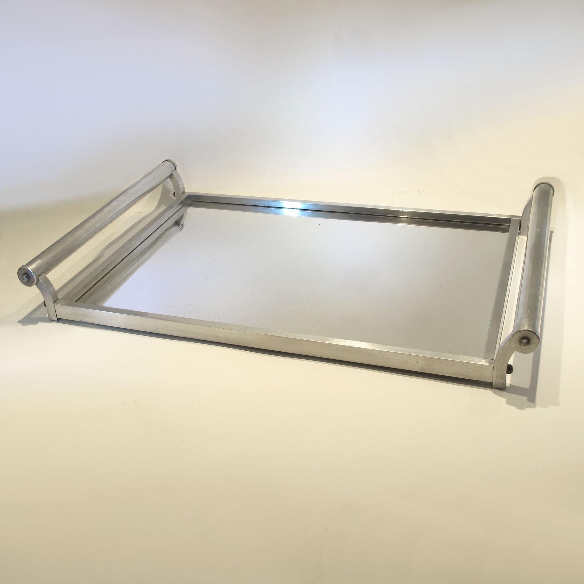 Large chic chrome tray in the style of Jacques Adnet. Modernist simple tubular chrome handles with square edged chrome frame and mirrored top. Original mirror shows some small signs of foxing. Wooden back.
