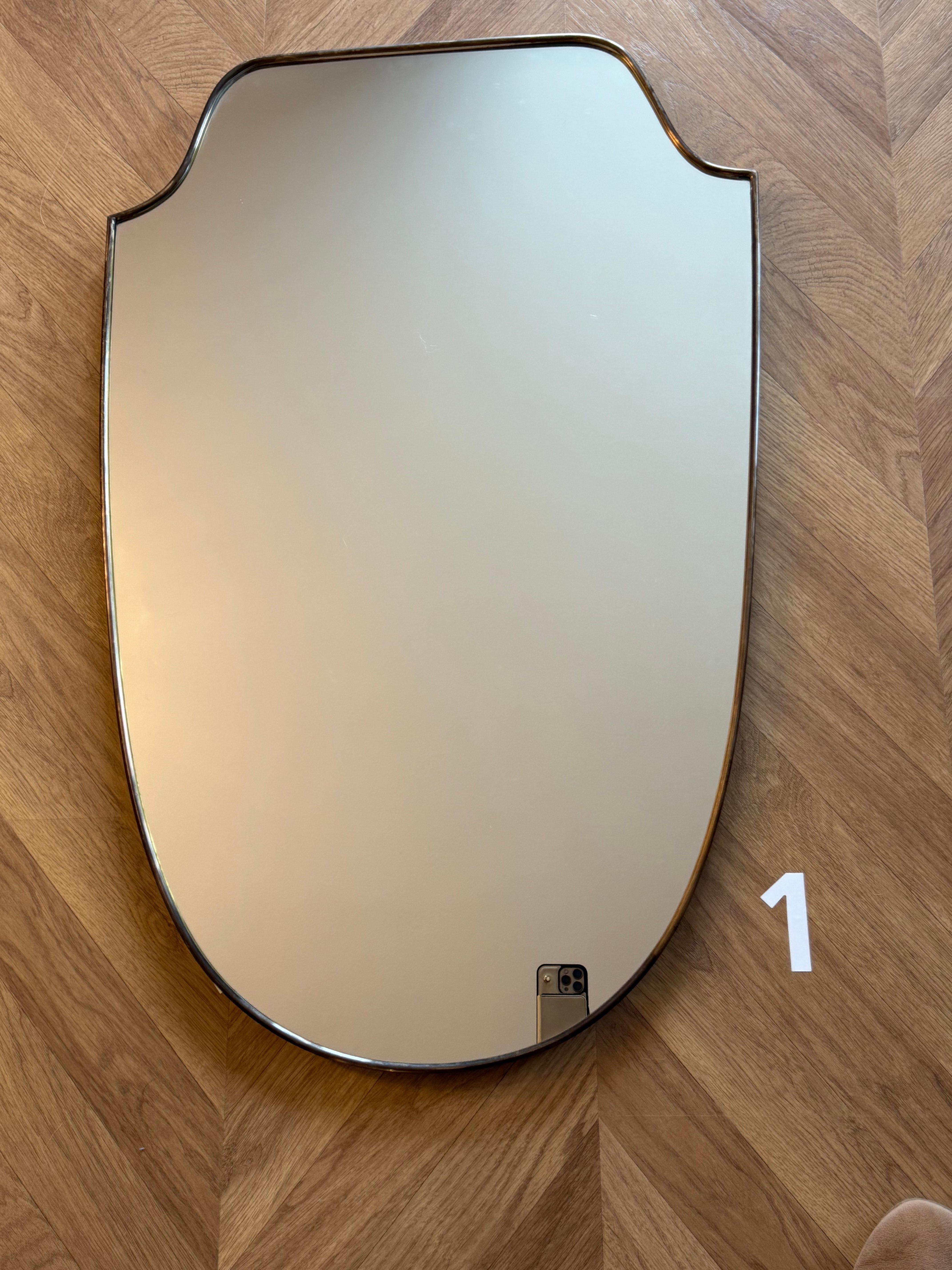 These very decorative mirrors were made in Italy in 1950s. It is typical of this period design and is all original. 
It could be hanged upon a wall on its own or mixed with other same style mirrors to get a spectacular look.
Its brass frame is thick