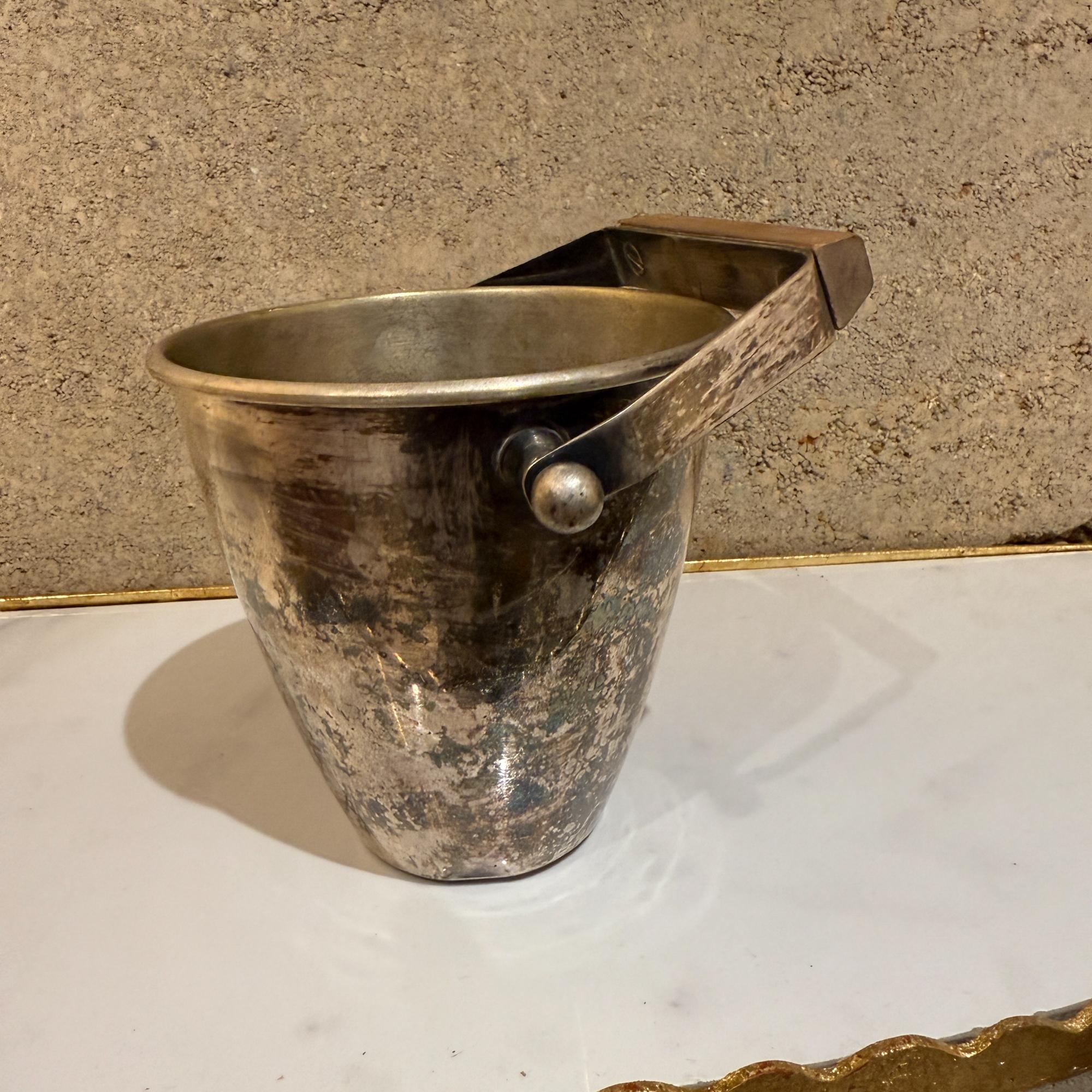For your consideration, a mid-century modernist silver plate ice bucket. Vintage ice bucket, silver plated with original vintage patina. Wood block (possibly mahogany) to add contrast to the modernist clean lines. Beautiful decorative and useful bar