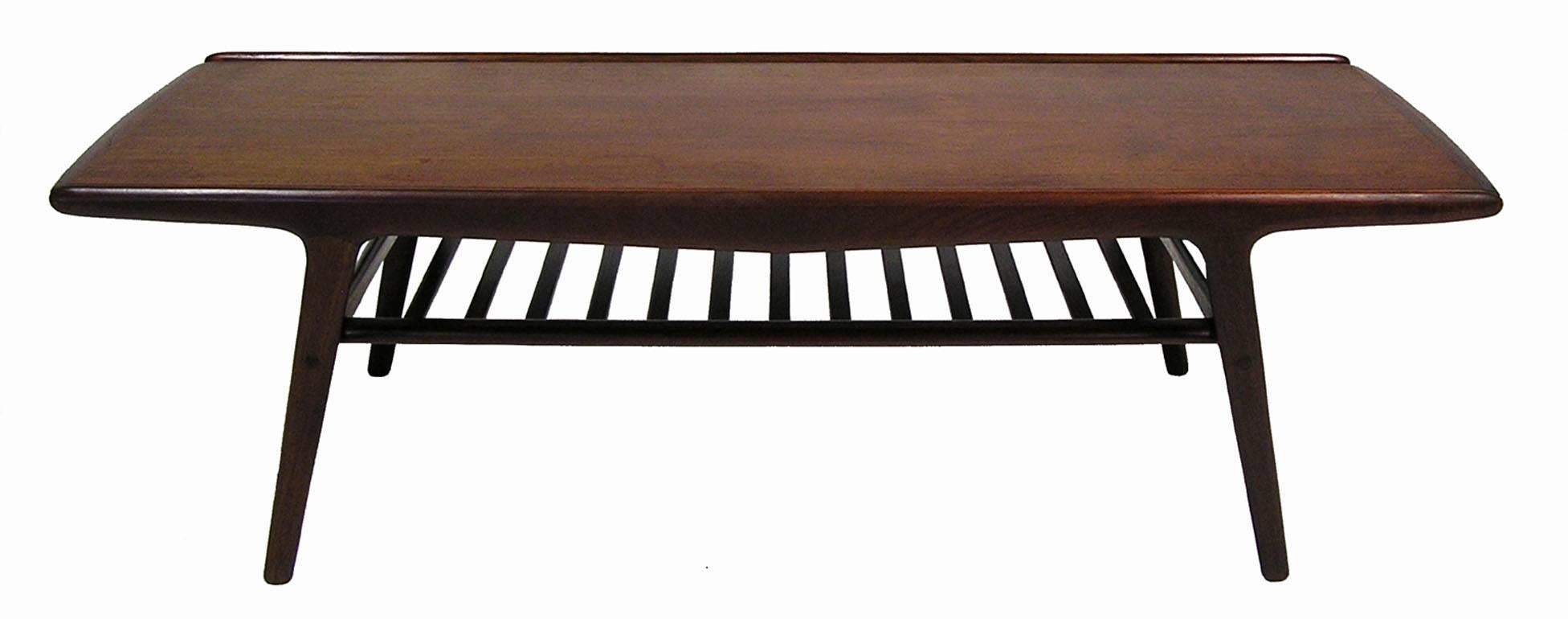 A rare teak coffee table from the 1950s designed by Arne Hovmand-Olsen for Mogens Kold of Denmark. Amazing craftsmanship throughout featuring stylish Danish Modern era lines with a uniquely designed inset floating top and slated lower shelf. A