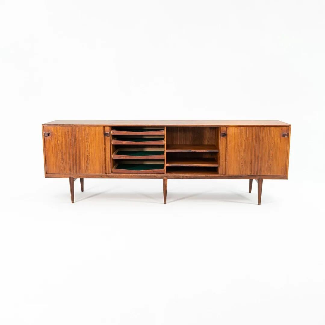 This is a truly “monumental” Danish credenza, designed by Henry Rosengren Hansen and produced by his company, Brande Møbelindustri. It was handcrafted in Denmark in the 1950s, executed in beautifully bookmatched Brazilian Rosewood. Rosengren Hansen