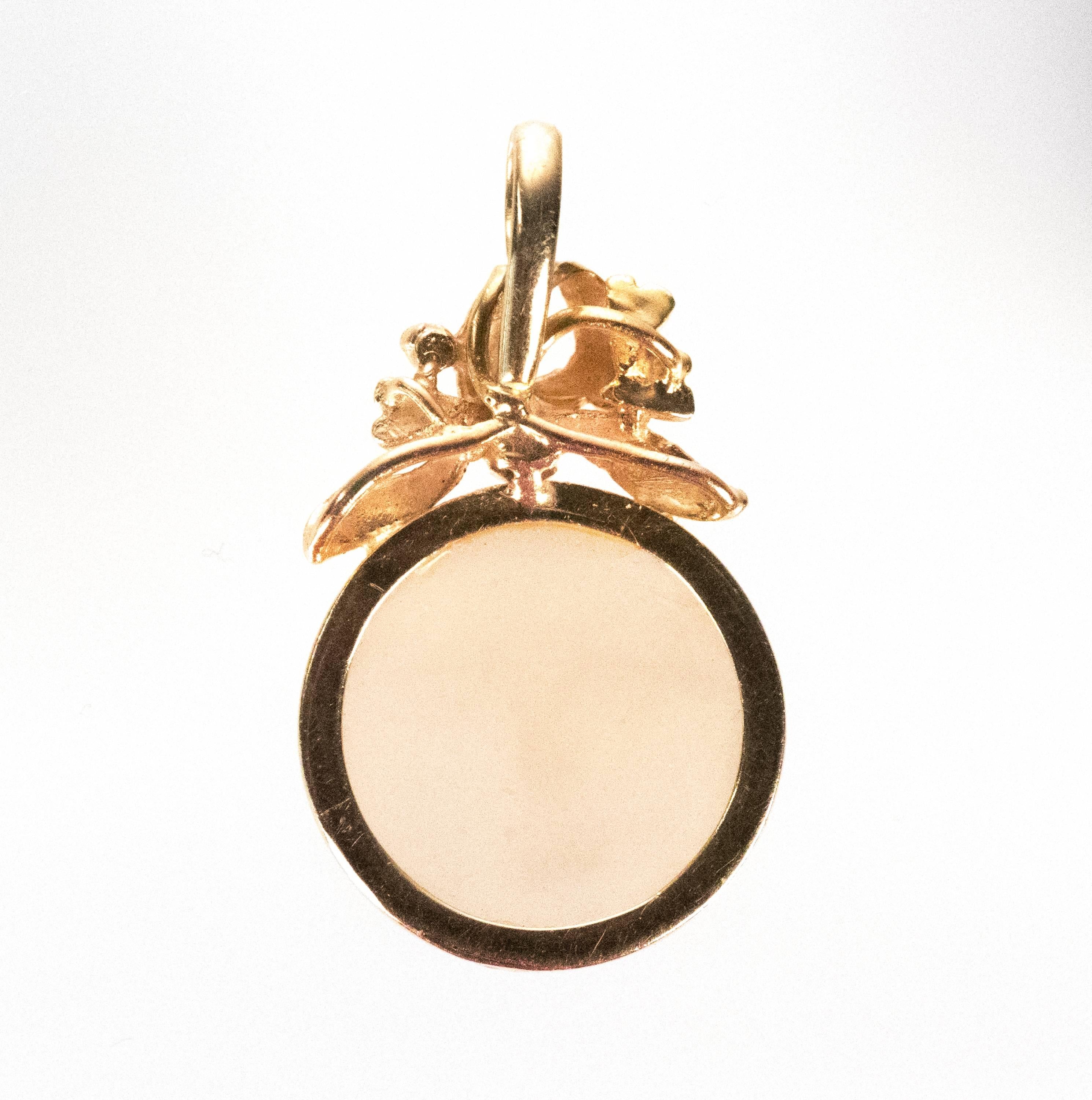 1950s Carved Moon Face Pendant - 18K Yellow Gold, Moonstone

Features a translucent Moonstone cabochon with a hand carved Moon Face front. This gorgeous Moonstone is set in rich 18 Karat Yellow Gold. The top of the frame has a ribbon motif with