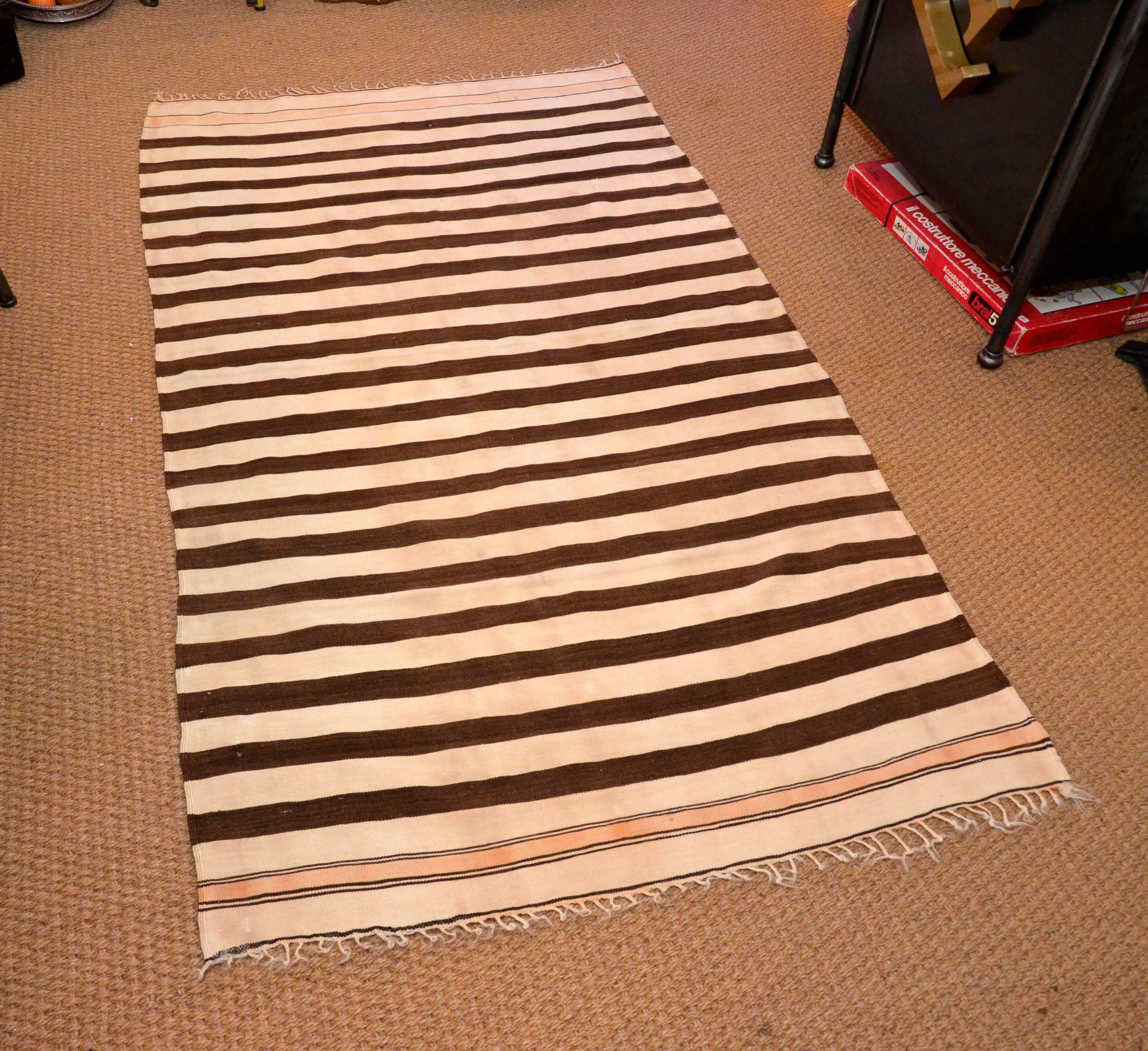 Mid-20th century handwoven natural wool stripes kilim from Morocco, North Africa, circa 1950s. Brown and cream not dyed color from sheep wool yarn.
Size: cm 186 x 110.
 