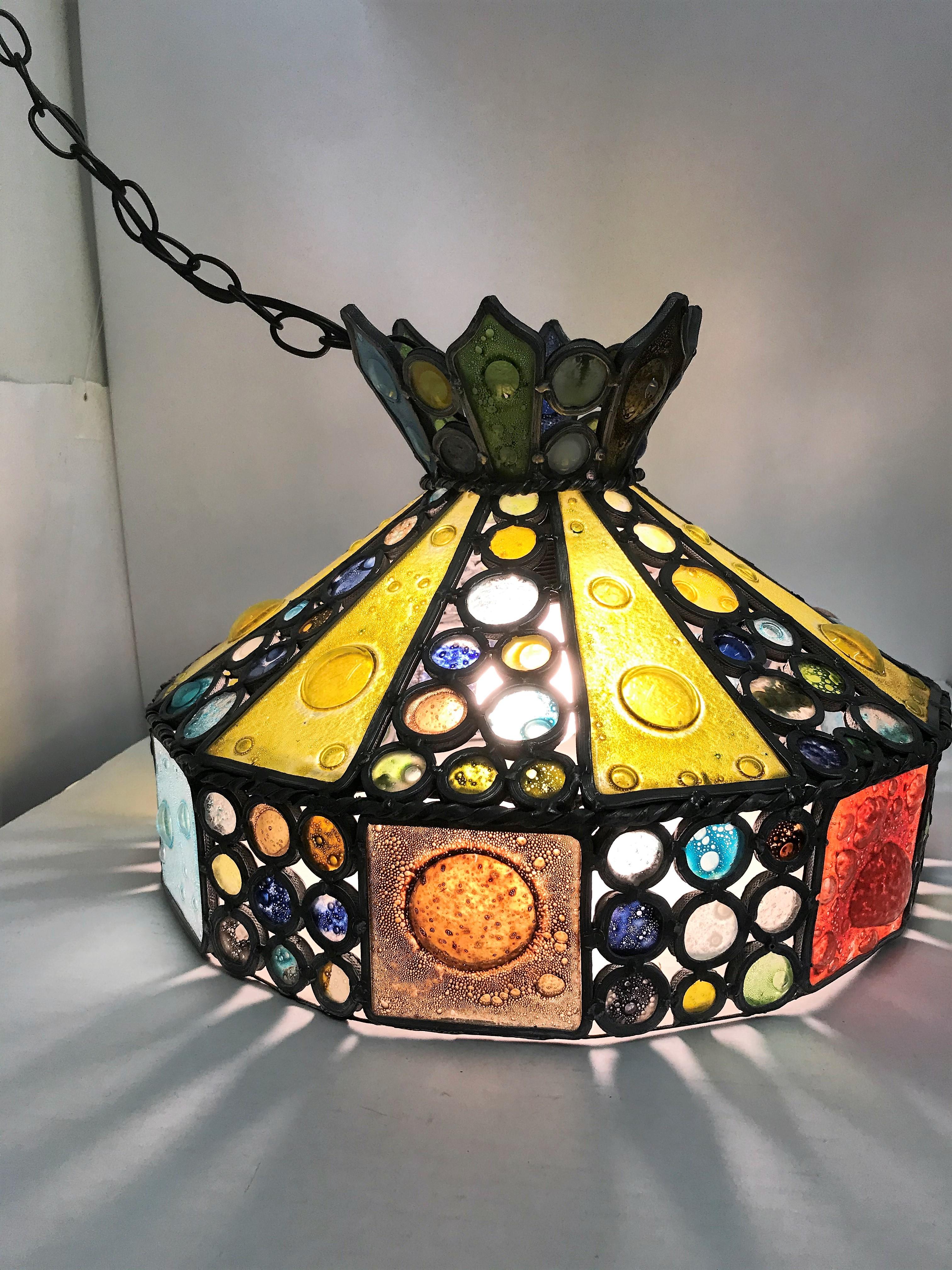 REDUCED FROM $1,200....With a classic Tiffany shape, this multicolored fused glass chandelier features a crown shaped top, sloping sides and horizontal band in bubbly fused glass with lead supports. Glass panels and jewel like circles throughout.