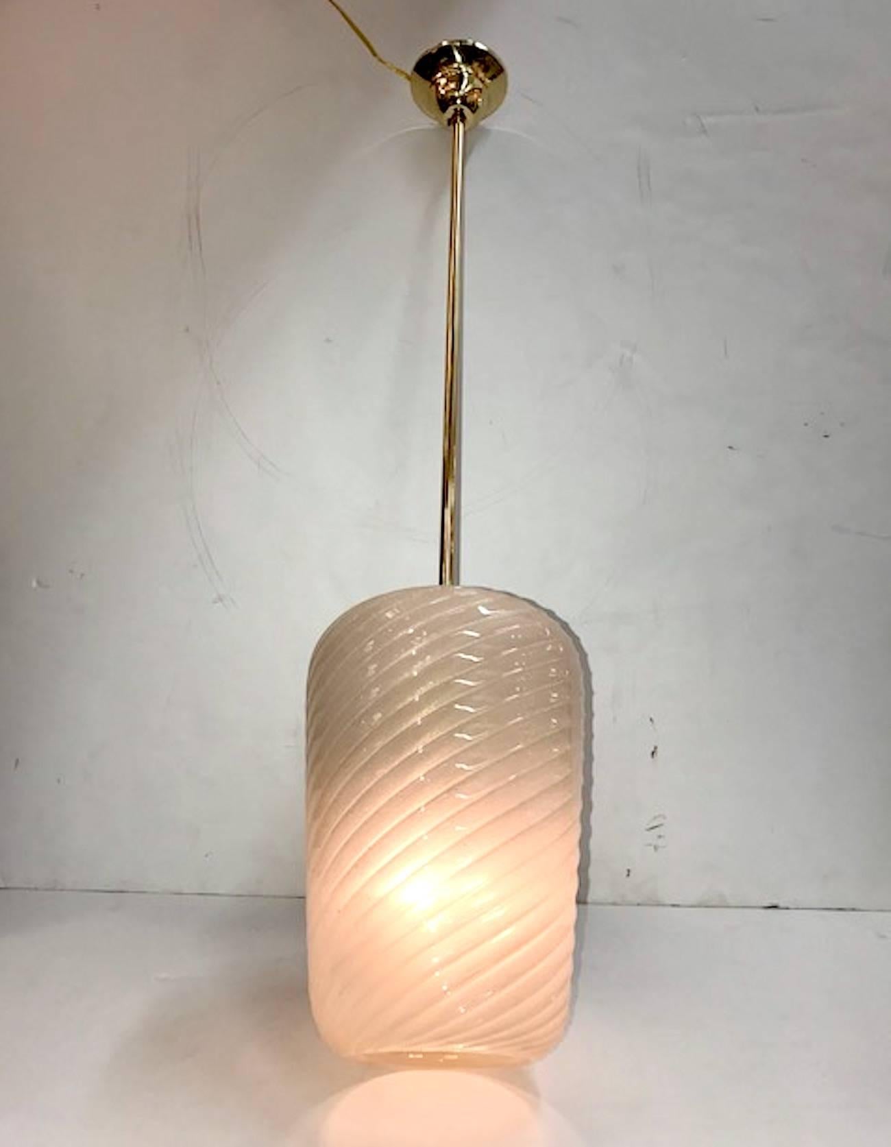 Italian circa 1950 pendant light in brass with handblown glass shade. The glass is opaque beige with gold flecks known as aventurine. The shade is handblown in with a spiral wide rib design and wider at the top and tapering slightly at the open