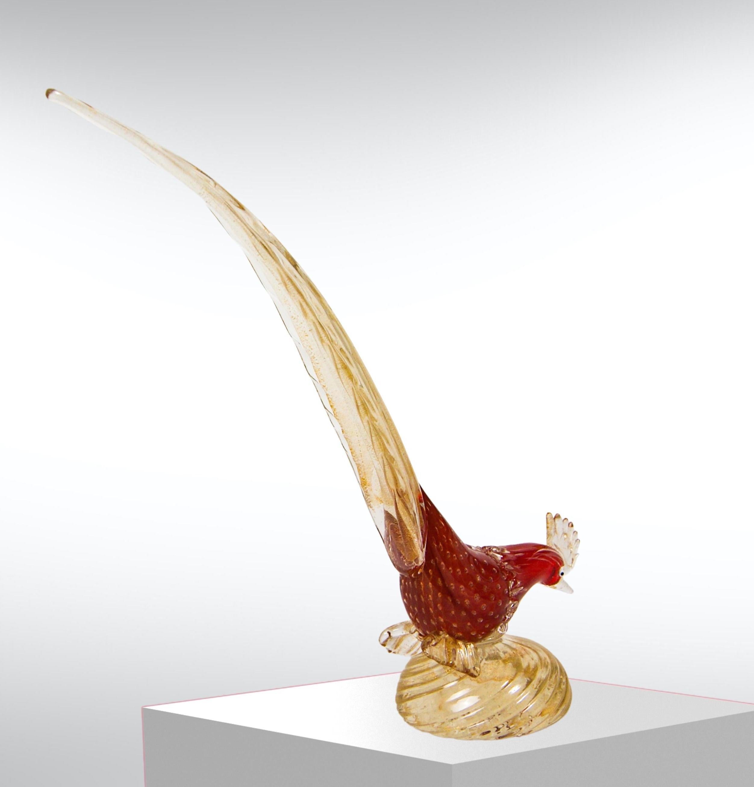 Vintage 1950s Murano glass bird sculpture.
Attribué à Barovier&Toso.
Elégante et haute sculpture de faisan en verre, de couleur rouge profond avec des bulles contrôlées et des inclusions dorées, le tout submergé de manière complexe dans un extérieur