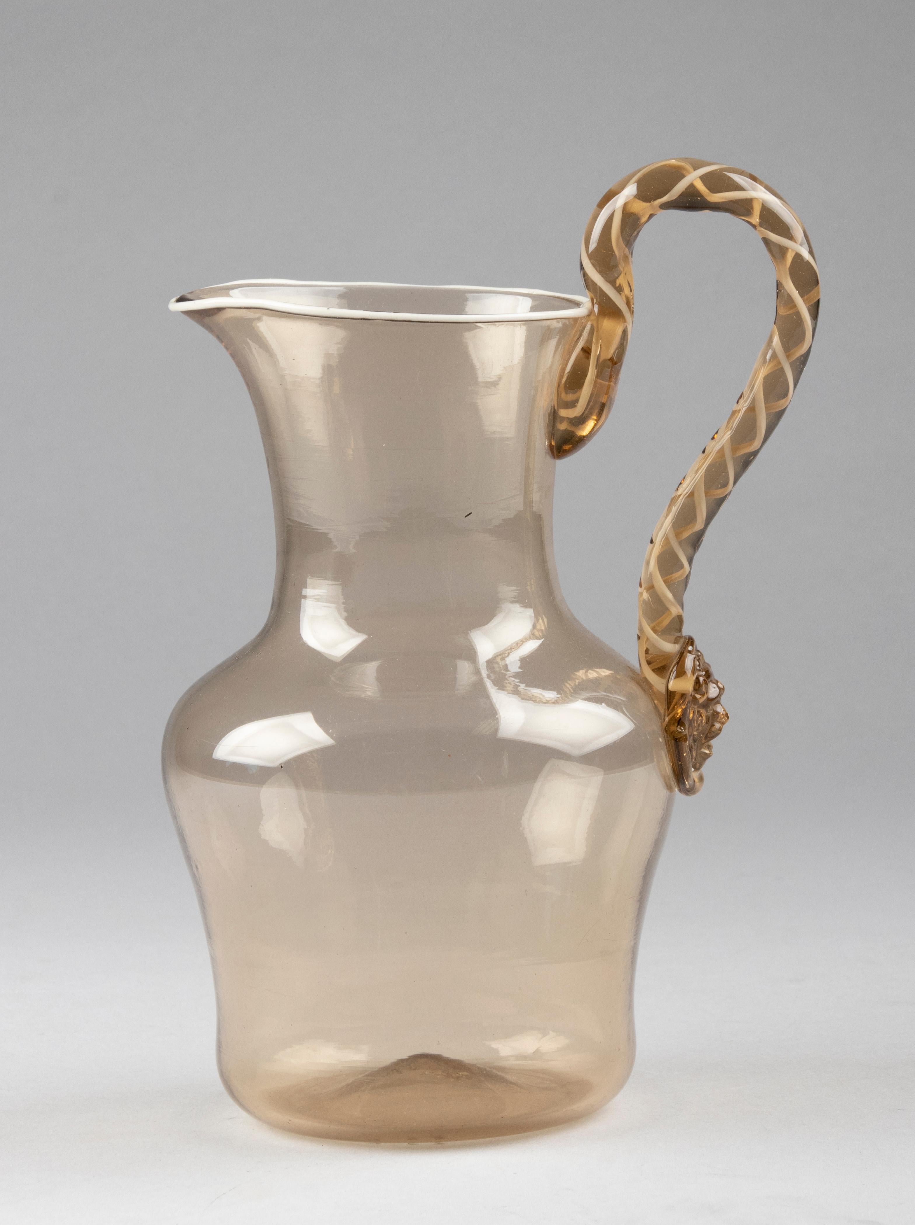Beautiful Murano glass water jug. Large model. Made of smoke colored glass, with fine accents of white lines. The handle is nicely decorated with a swirl. In good condition.