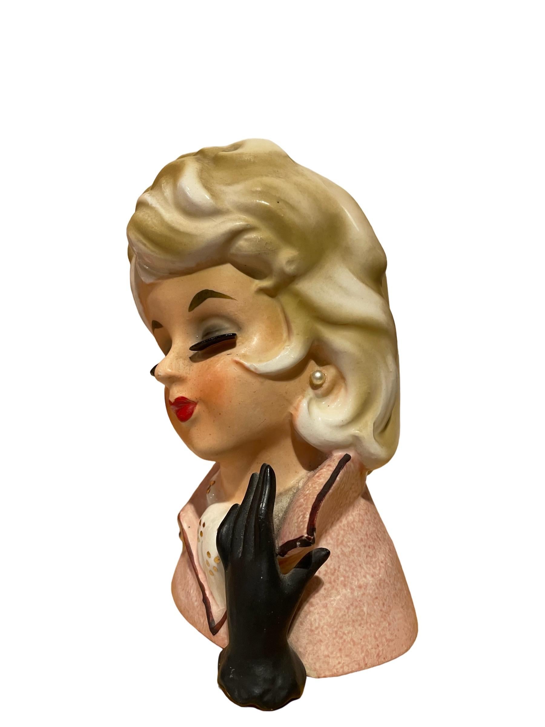 1950er Napcoware Lady Head Vase 

Adorable 1950s Blonde Dame Kopf Vase mit langen Wimpern, rosa Mantel, Perlenohrringe, Gold Akzente auf Bluse, und schwarzer Handschuh. 

Ungefähr 6