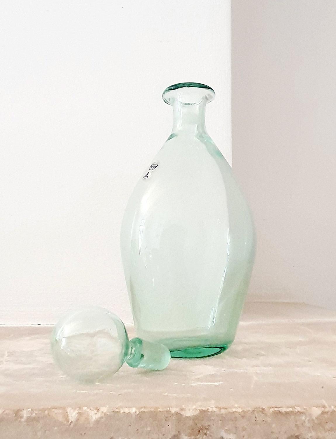 Une magnifique bouteille / carafe verte pâle soufflée à la main avec un bouchon soufflé à la main par le fourneau vénitien, Nason Moretti. La bouteille porte encore l'étiquette de Nason Moretti. Il s'agit d'une belle pièce en excellent état.