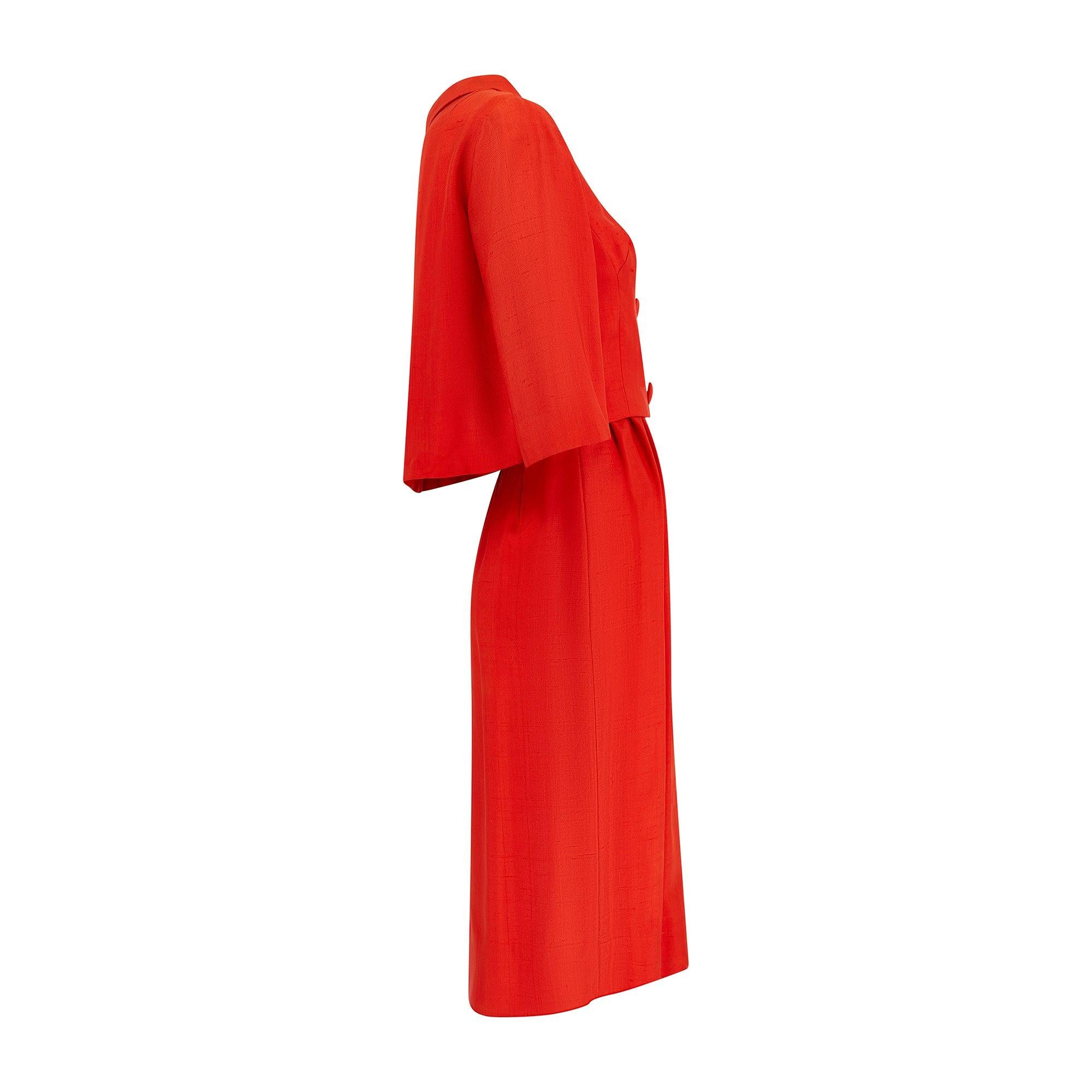 Cet ensemble de robes et de vestes datant de la fin des années 1950 au début des années 1960 a été conçu par August pour Nathan-Strong. Le tissu est époustouflant et est taillé dans une soie grattée d'un rouge-orange éclatant. La robe est taillée