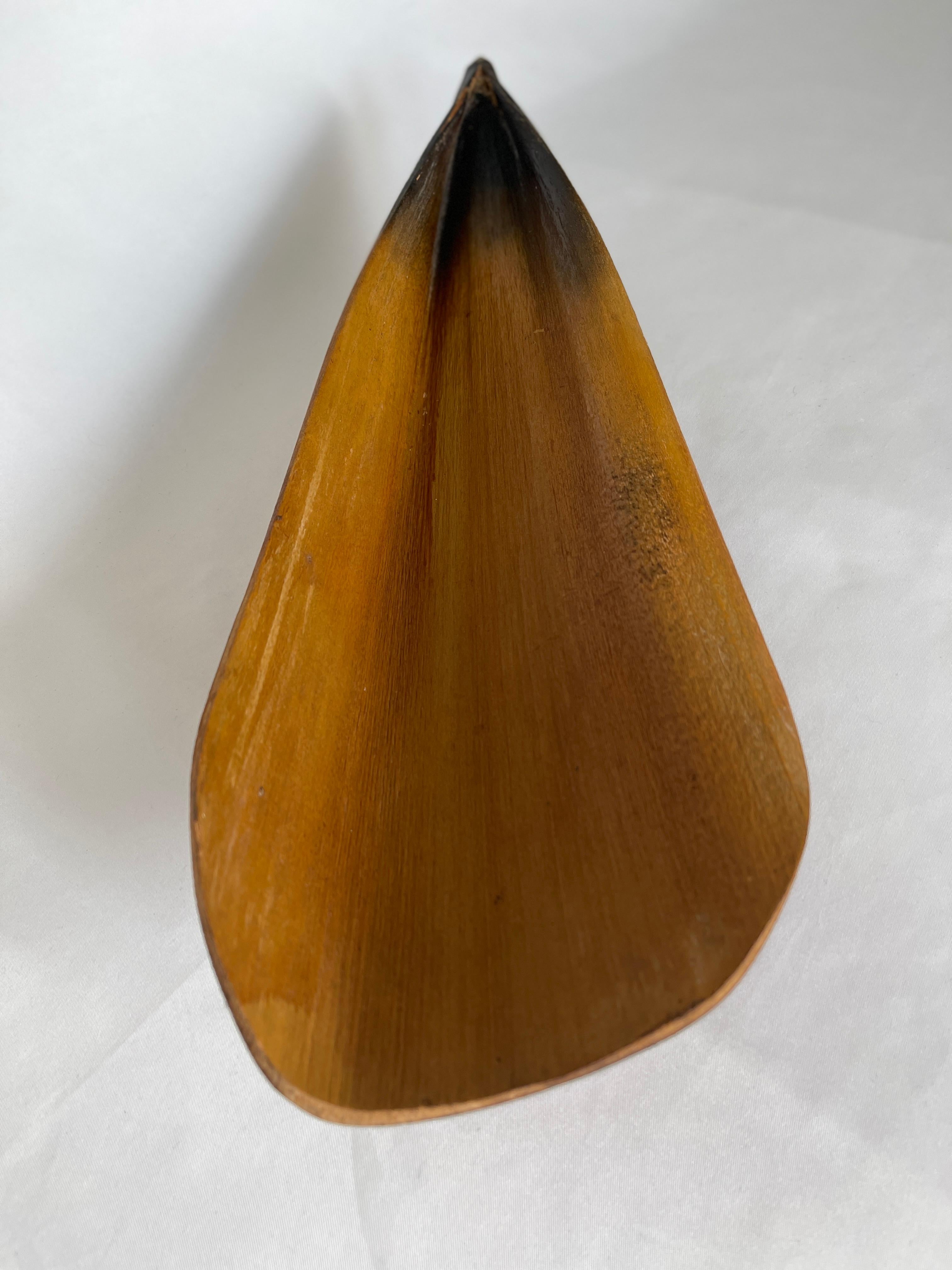 Natural Florida long palm leaf centrepiece tray with two balancing round wood ball legs Tray was crafted by drying and molding the leaf to the curved shape, perfect for display on a table or shelf.