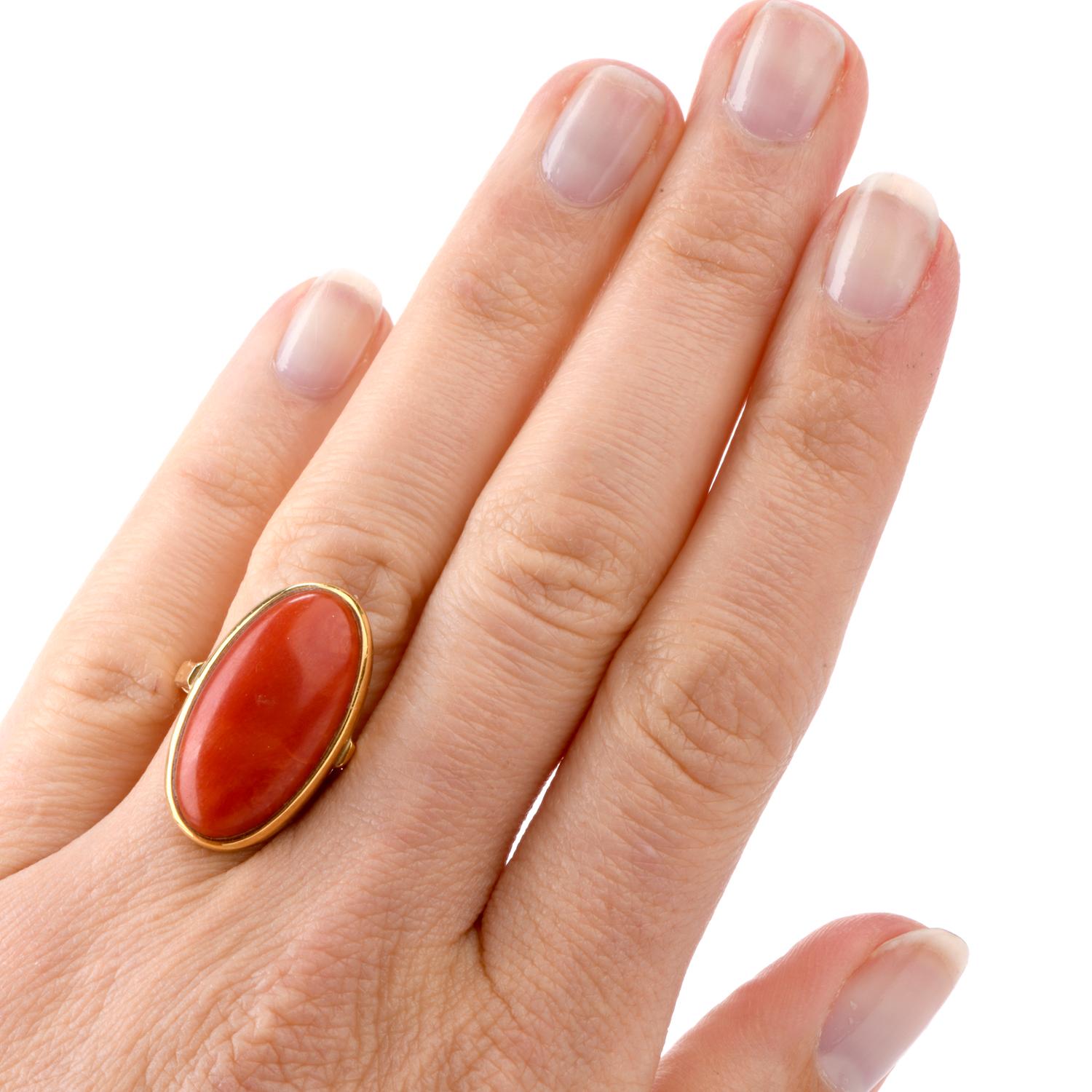 Simple is Elegant! This vintage cocktail ring features one very large elongated oval shaped Natural Red Coral  measuring appx. 23.63 x 11.72mm

and was crafted in 18K yellow gold. Stamped 750, this ring remains in Very Good Condition.

Currently a