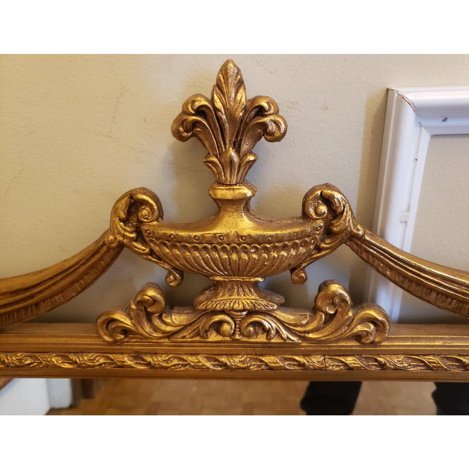 This neoclassical-style gilt mirror is embellished with drapery caught at the corners by rosettes and topped by a stylized urn. The inner border is composed by an egg-and-dart motif. Perfect for a hall console, above a mantel (fireplace) or over a