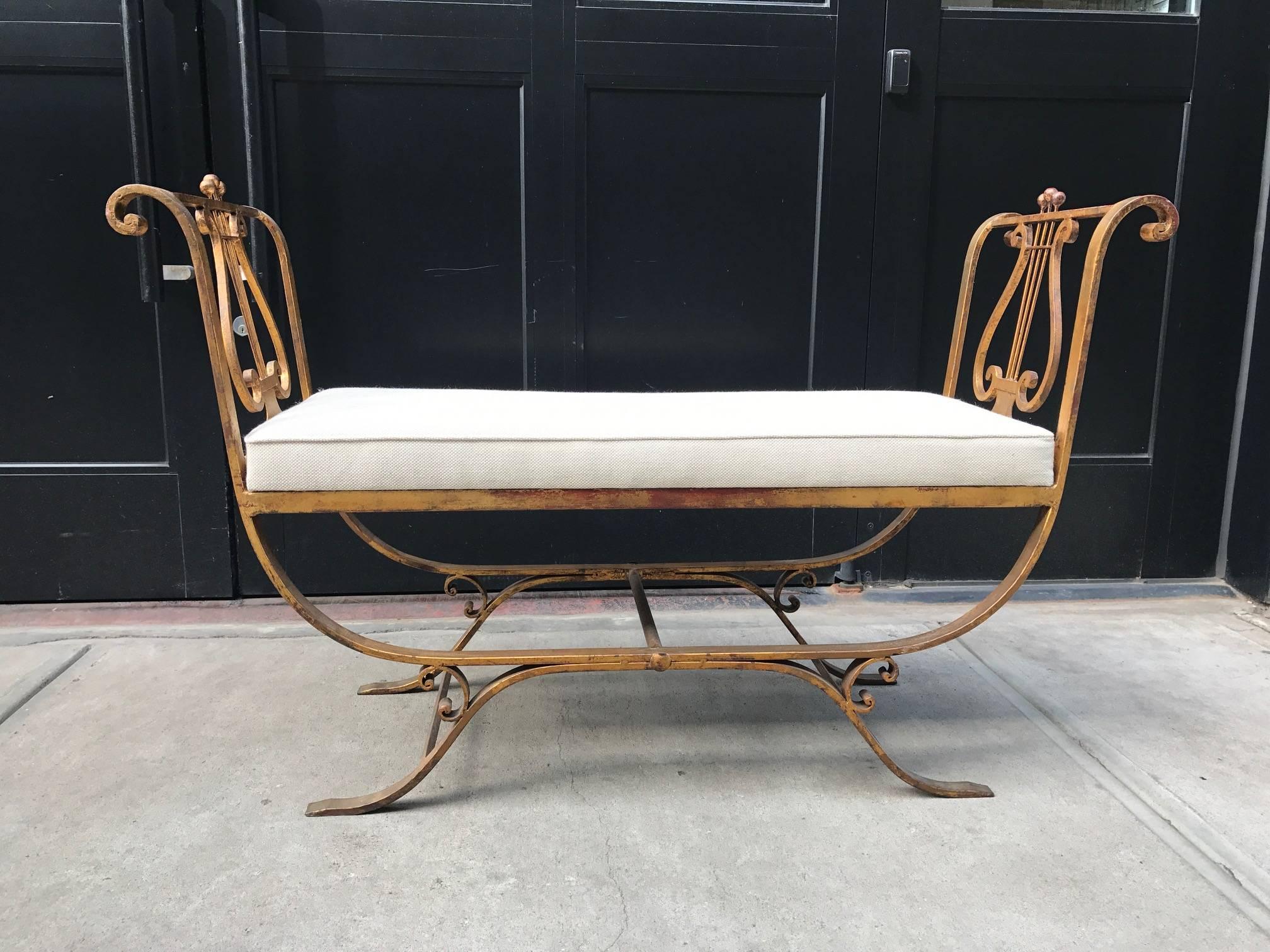 Neoclassical style gold gilt iron bench. Has a newly upholstered linen cushion.