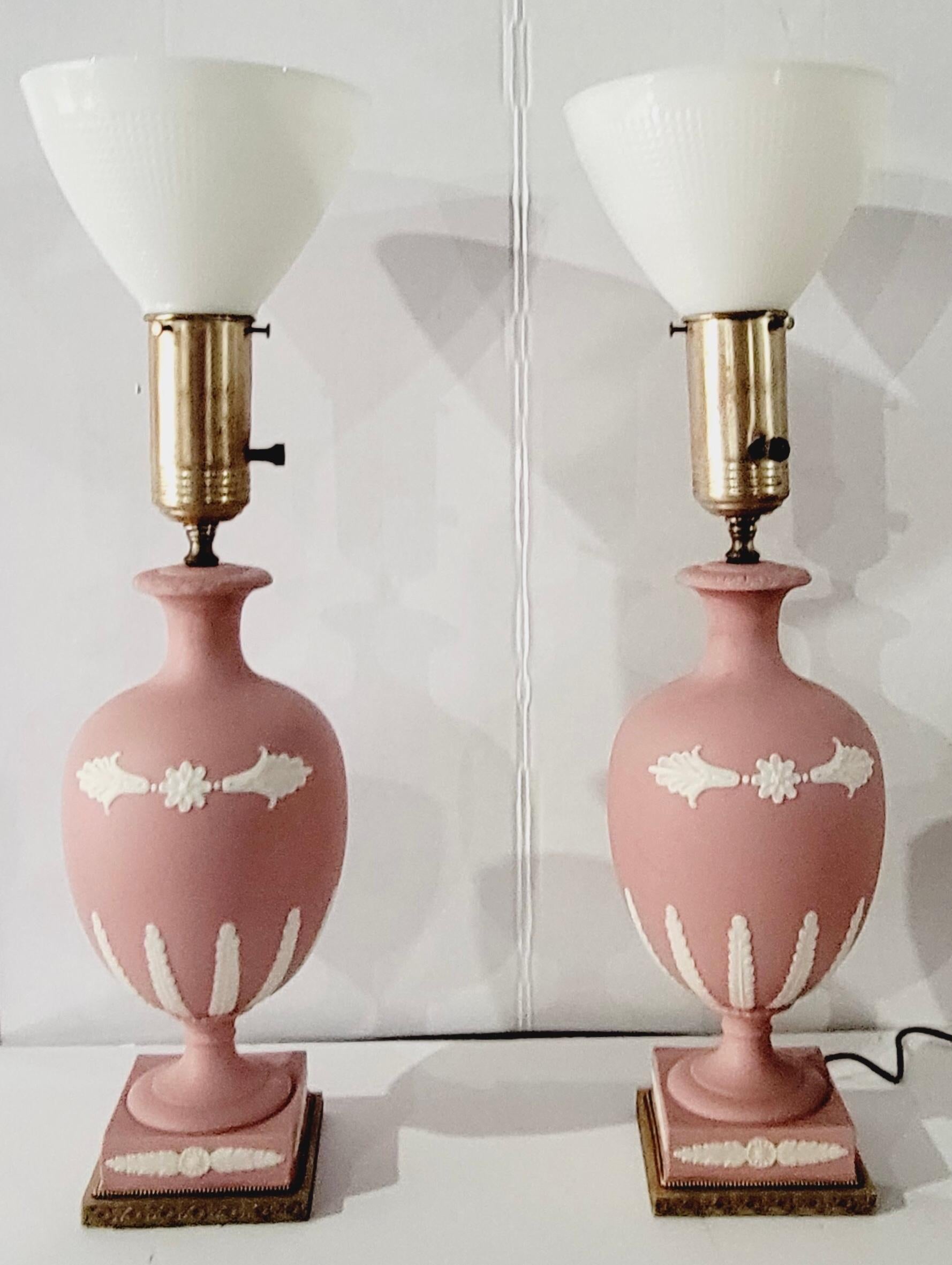 This is a lovely pair of 1950s neoclassical style pink basalt pottery lamps attributed to Wedgwood. They even have the original milkglass shades! They are in very good condition.