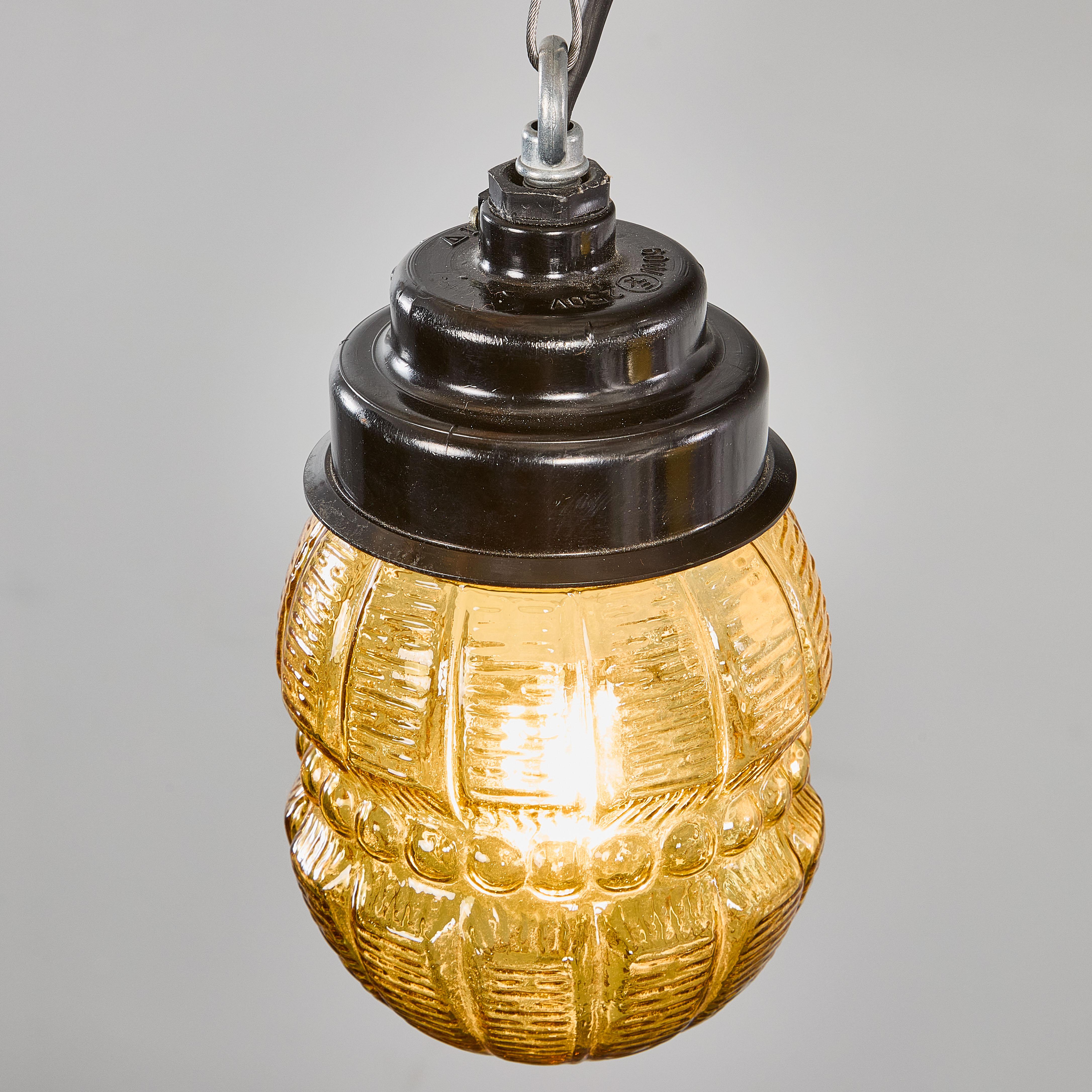 1950's New Old Stock Amber Barrel Pendant Lamps - Unique Pair. 

The gallery tops are original Bakelite (self insulated) and simply screw into the amber decorated glass barrel. Each lamp has been cleaned and restored. Listing is for one lamp. Each